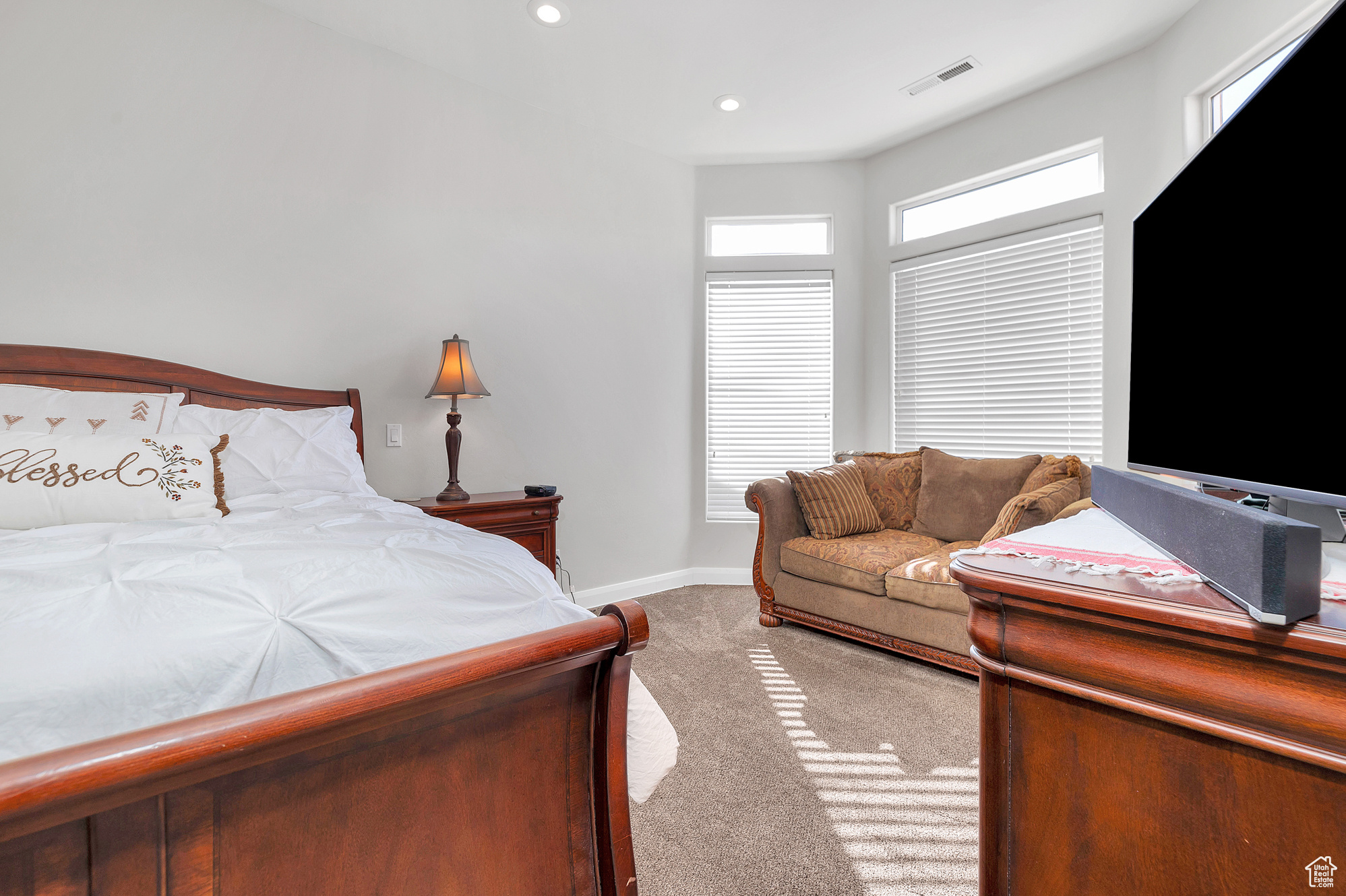 Carpeted bedroom with visible vents, recessed lighting, and baseboards