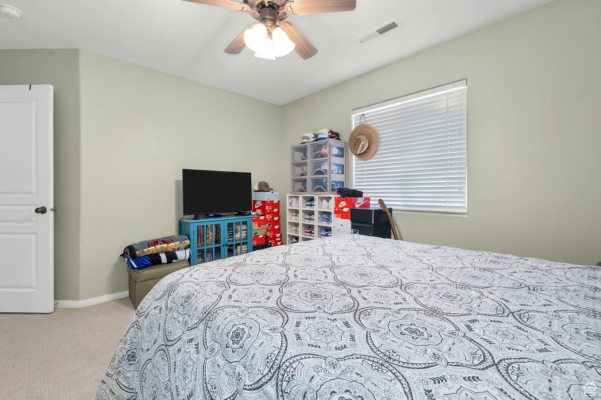 Carpeted bedroom featuring visible vents, ceiling fan, and baseboards