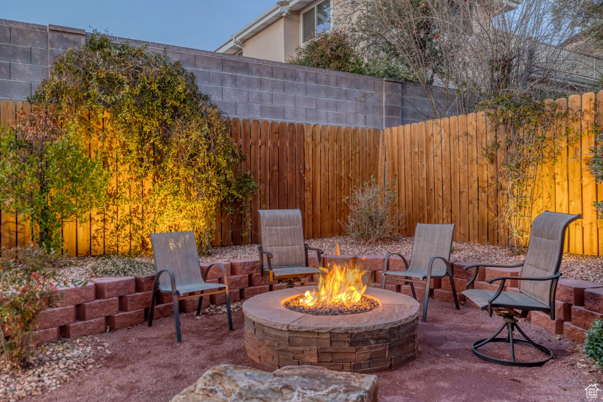 View of patio featuring an outdoor fire pit and fence