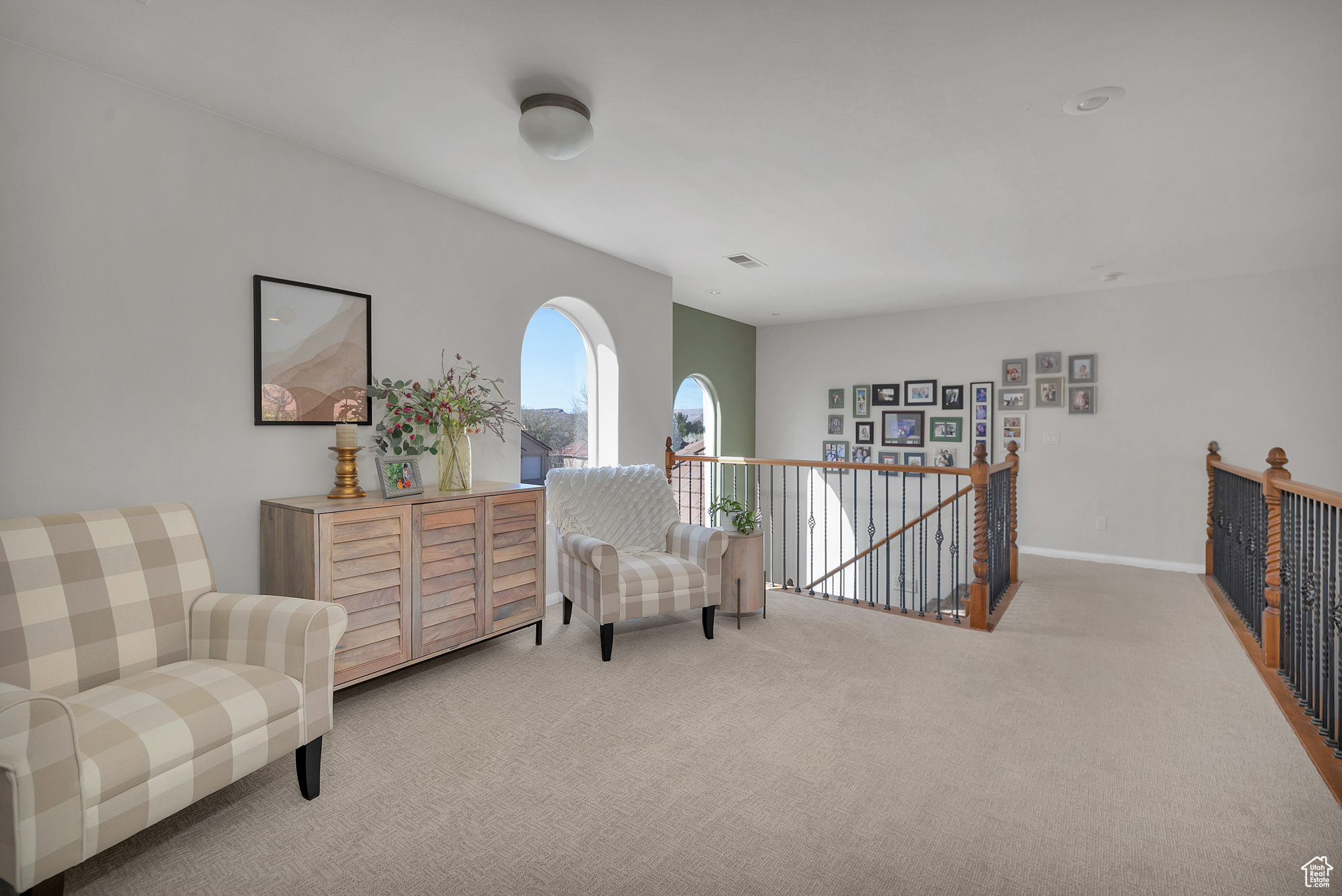 Sitting room with carpet, an upstairs landing, and baseboards