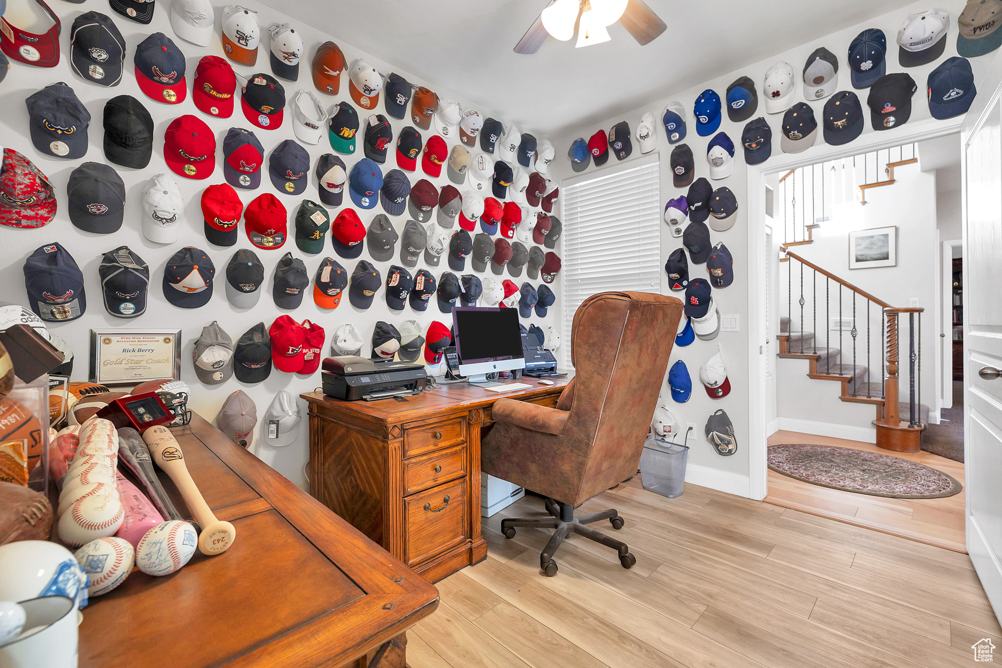 Office space featuring light wood-style flooring, a ceiling fan, and baseboards