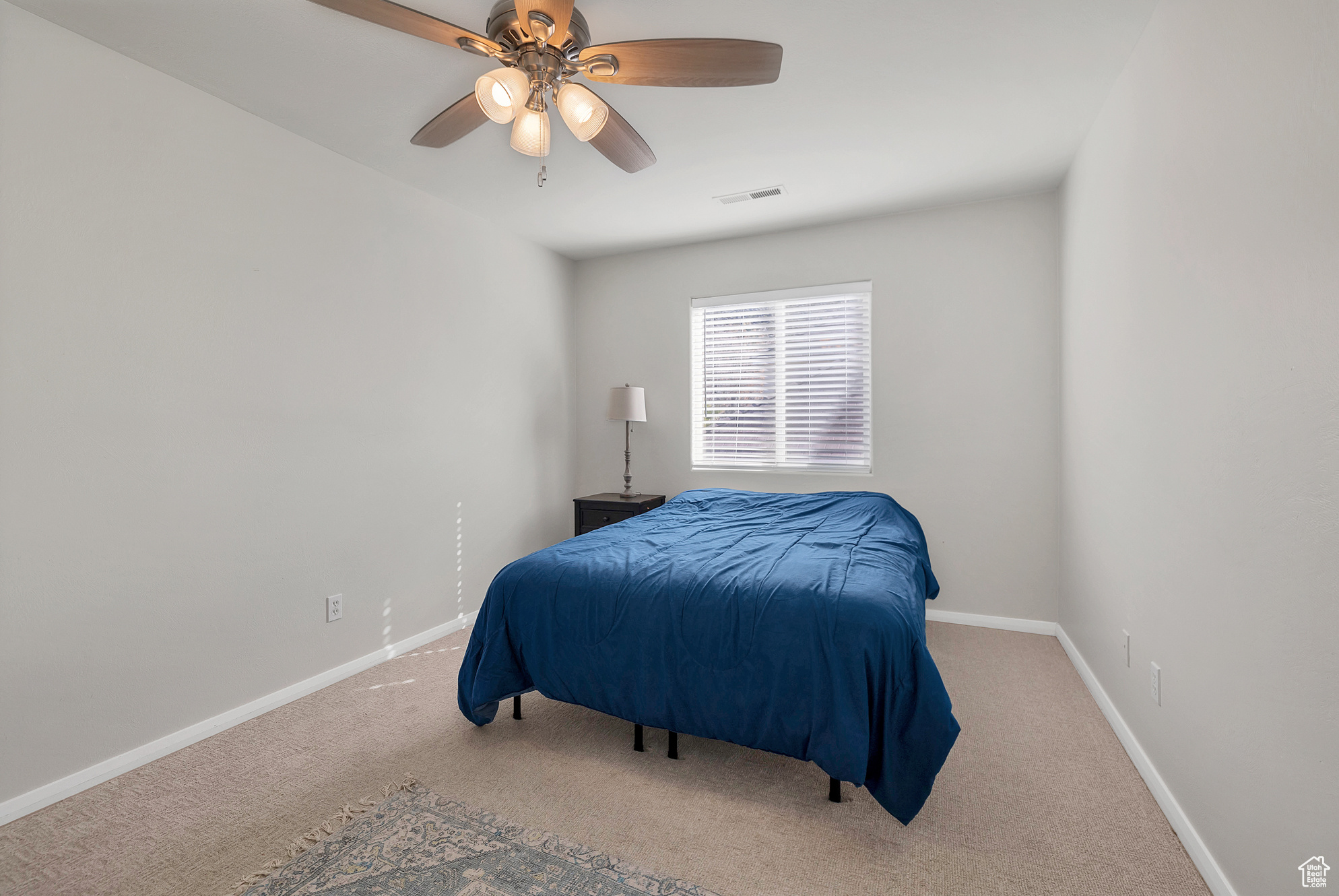 Carpeted bedroom with visible vents, a ceiling fan, and baseboards