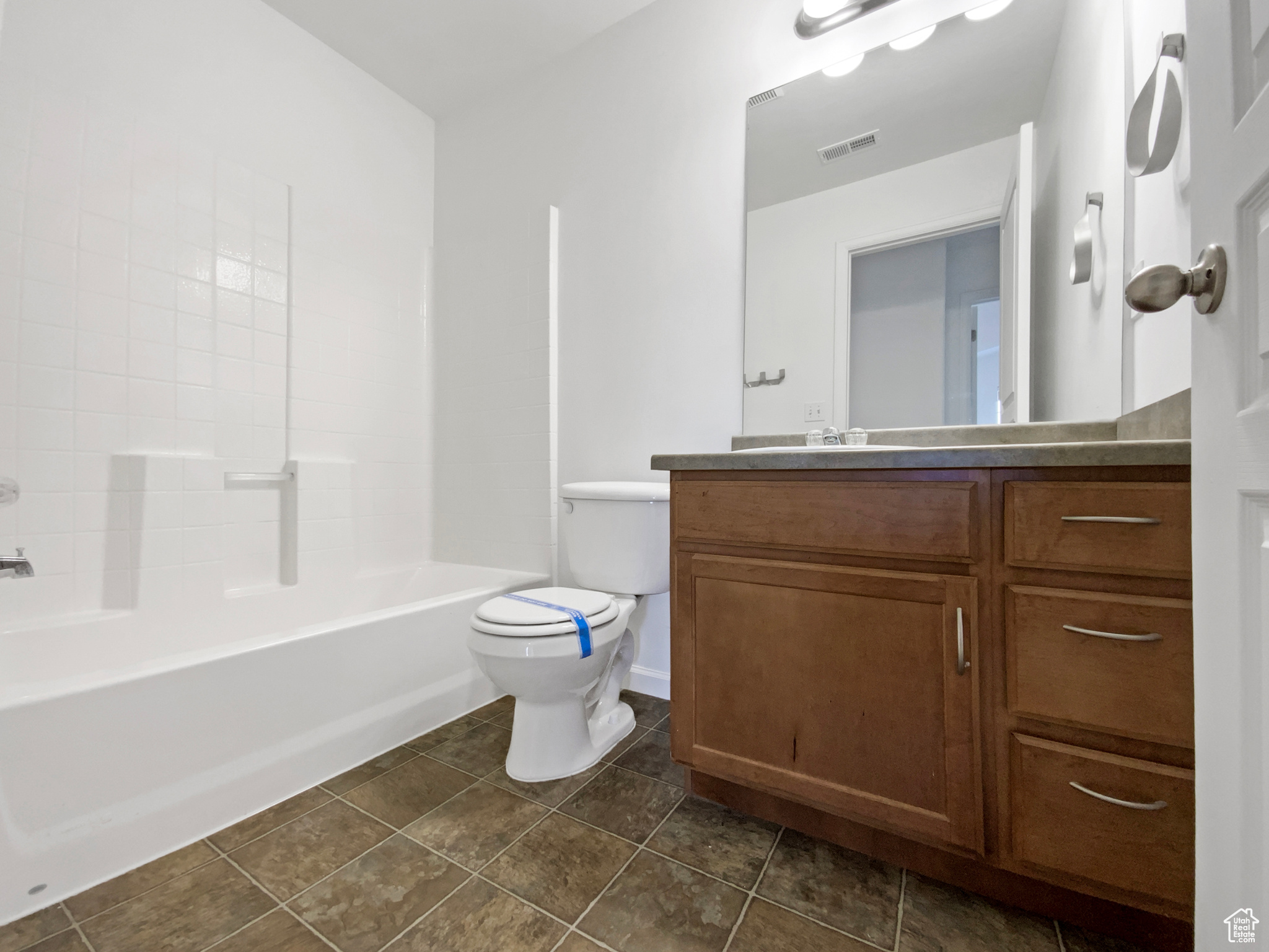 Bathroom featuring tile patterned floors, visible vents, toilet, and vanity