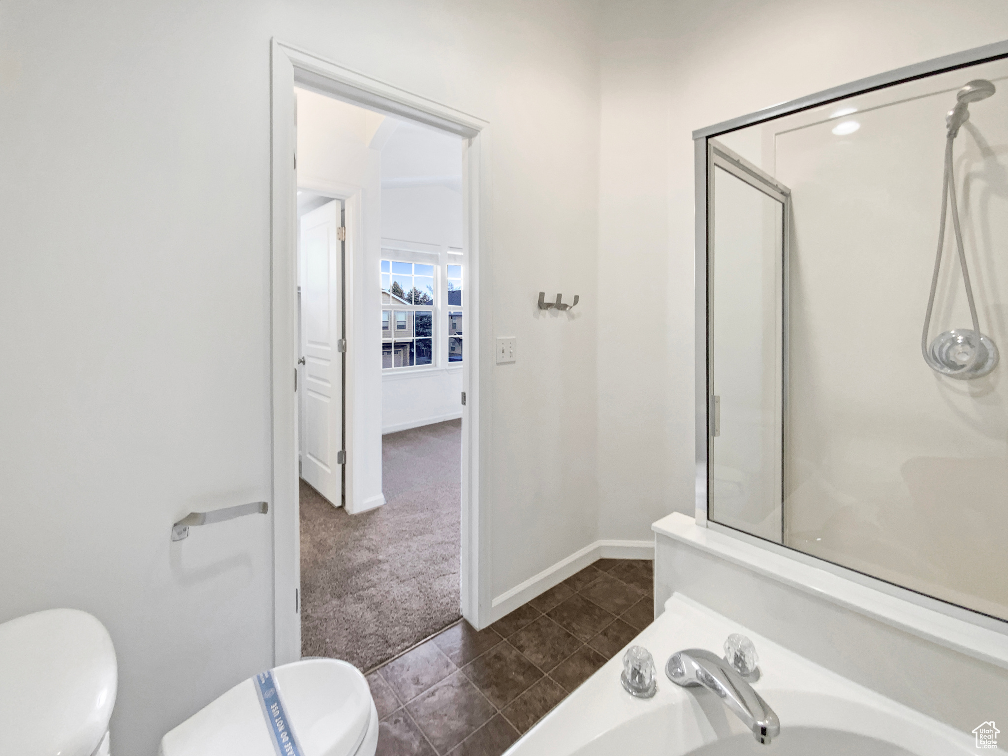 Full bathroom featuring tile patterned floors, toilet, a shower, and baseboards