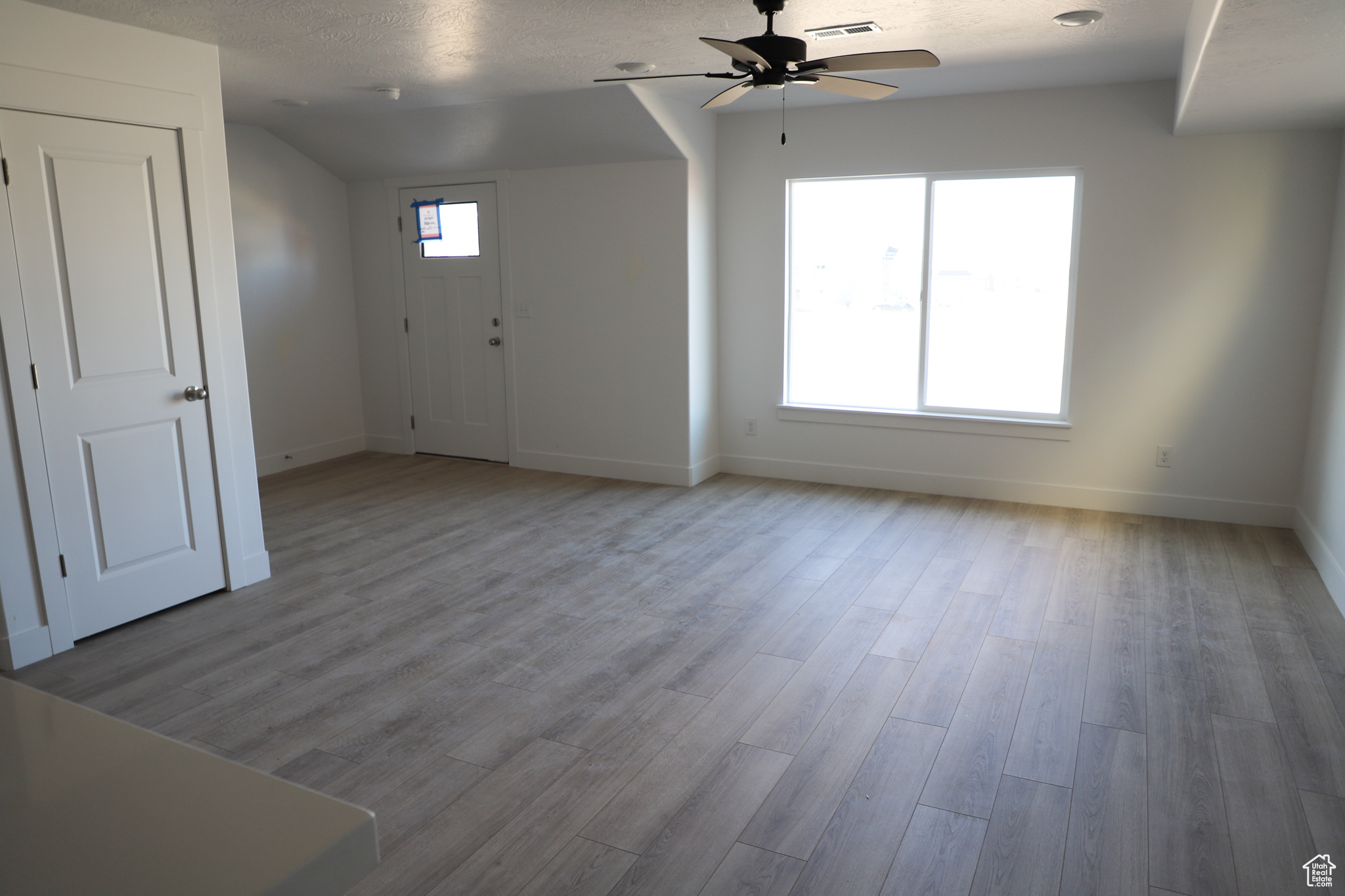 Interior space featuring ceiling fan, visible vents, baseboards, and wood finished floors