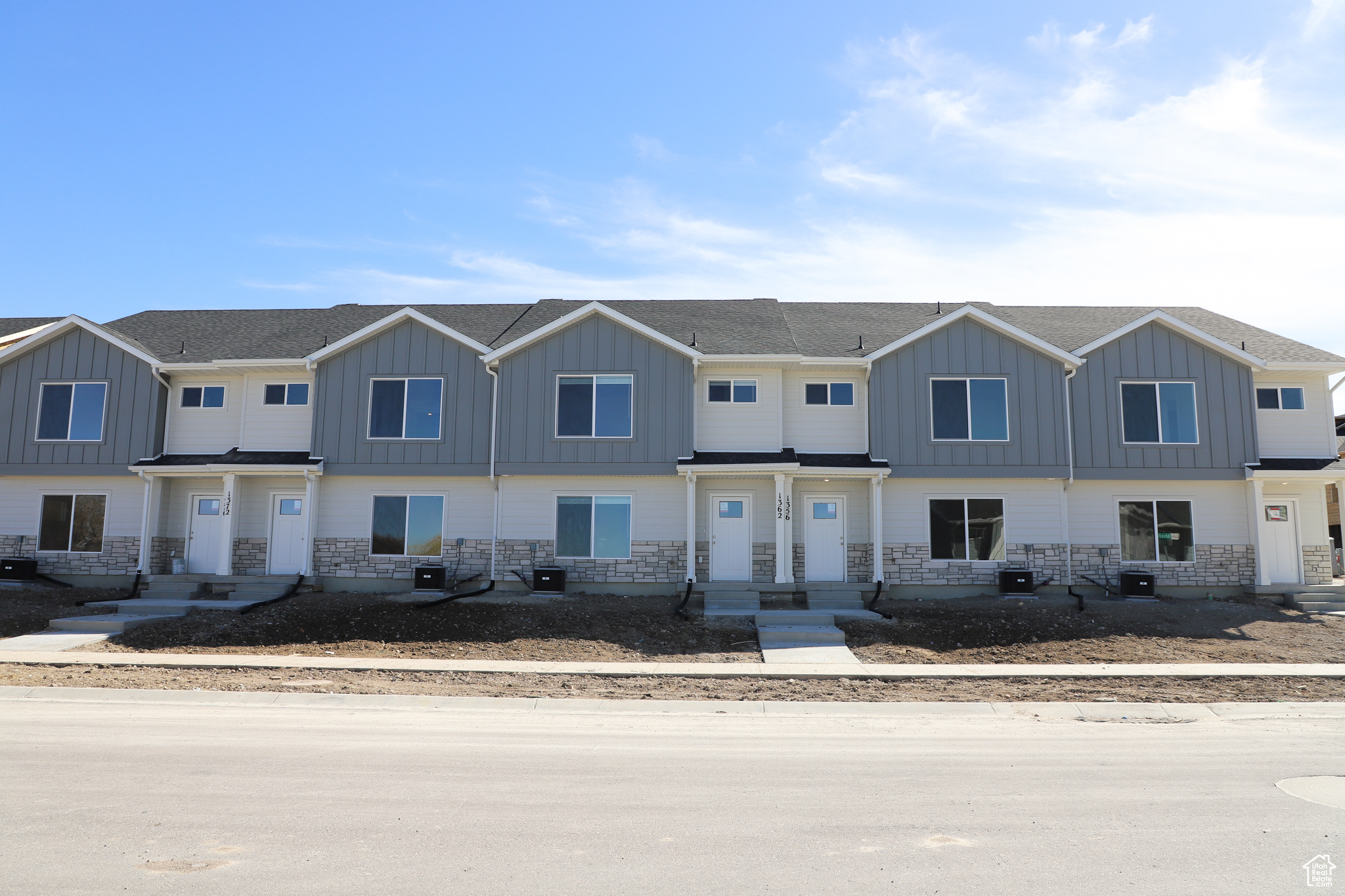 Multi unit property with cooling unit, stone siding, board and batten siding, and a shingled roof