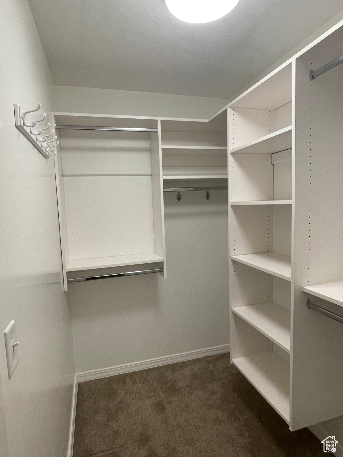 Walk in primary closet featuring built-in organizers