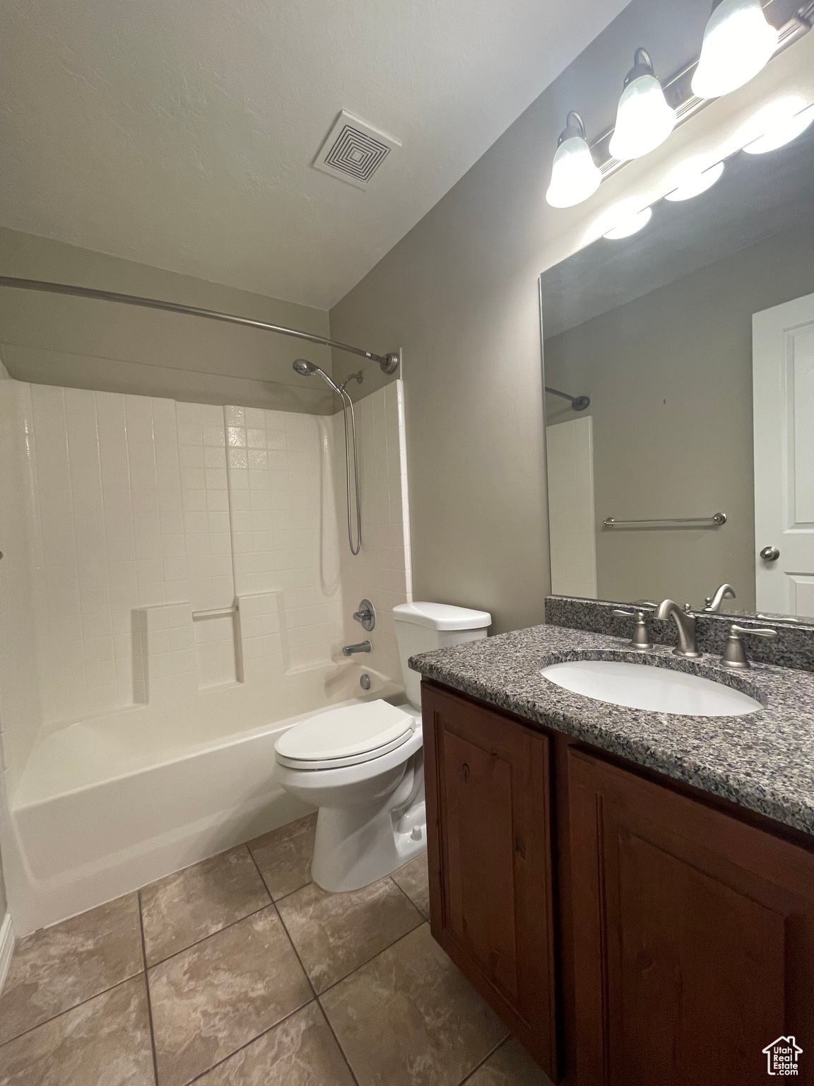Full bathroom featuring tile flooring, toilet, shower / tub combination, and stone-top vanity