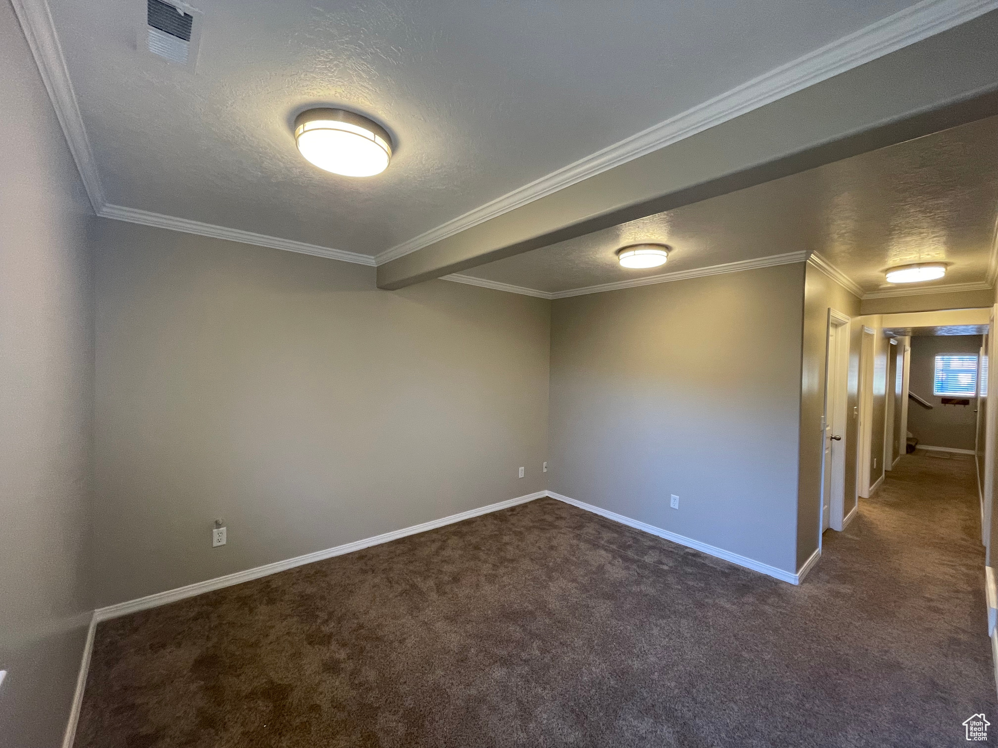 Family room with textured ceiling, carpet, and baseboards