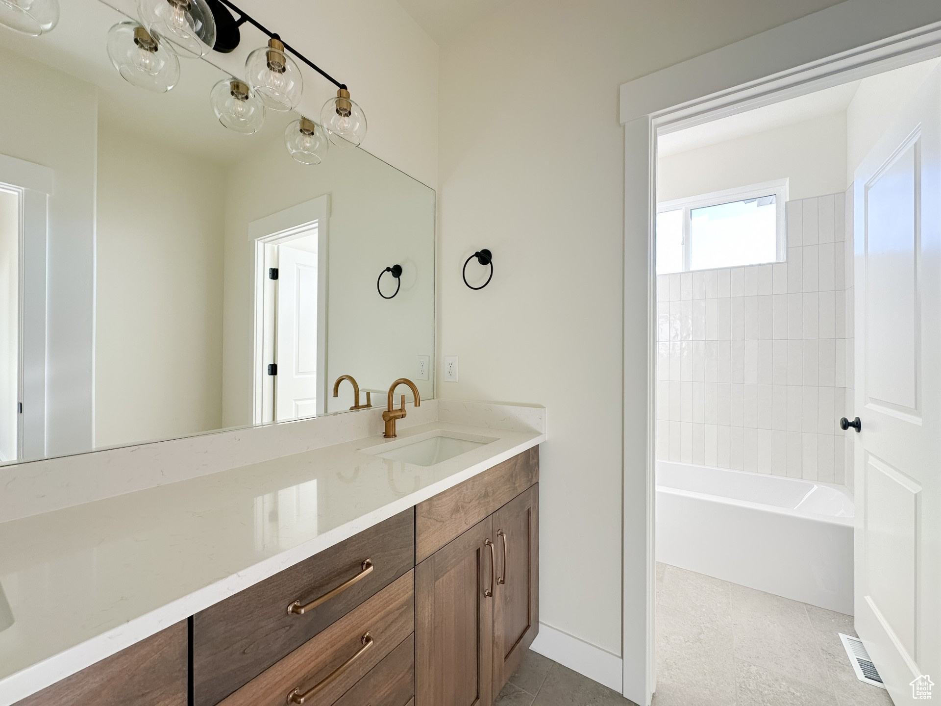 Full bathroom with vanity, visible vents, and tile patterned flooring