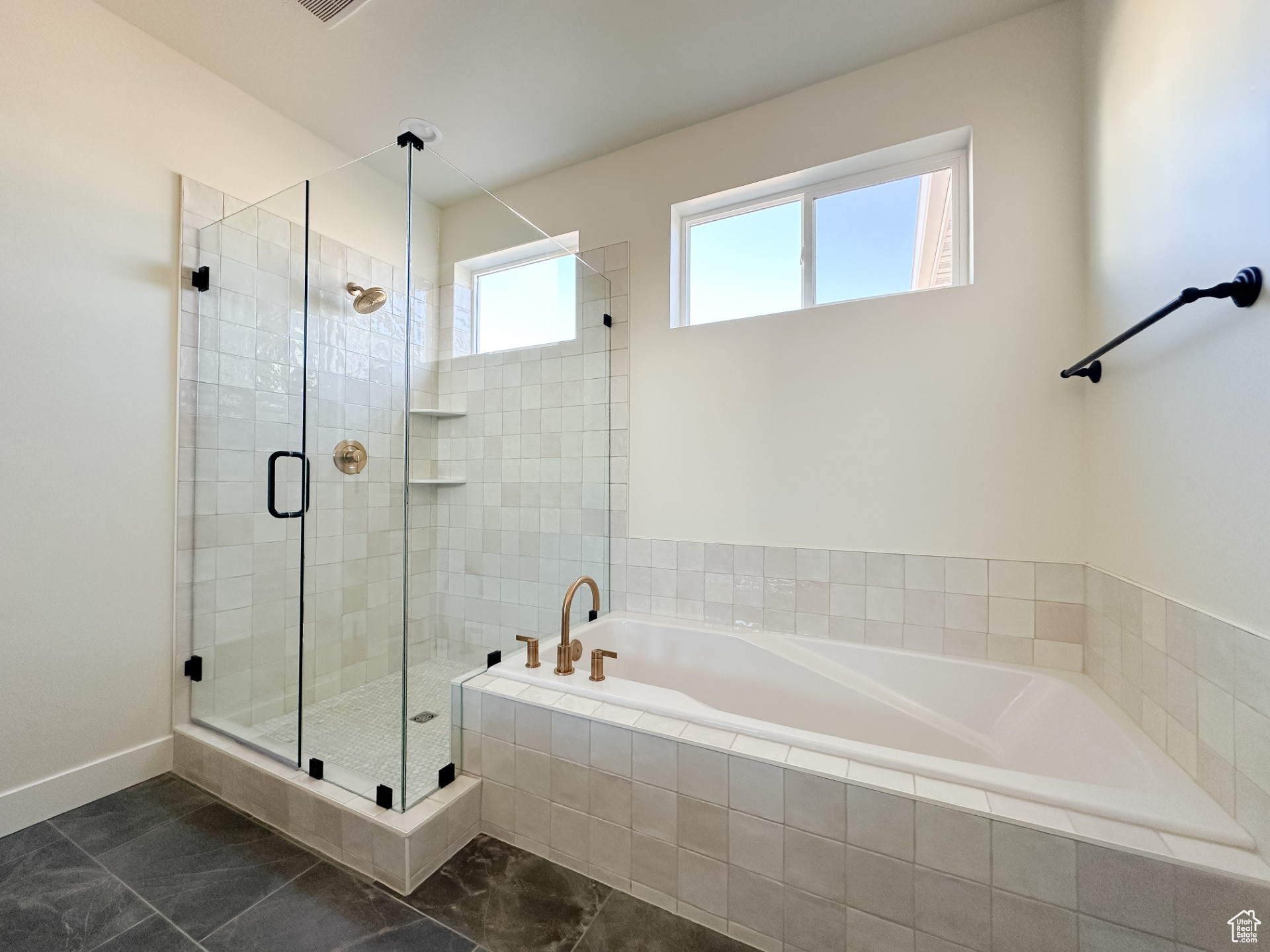Full bathroom featuring baseboards, a garden tub, and a shower stall