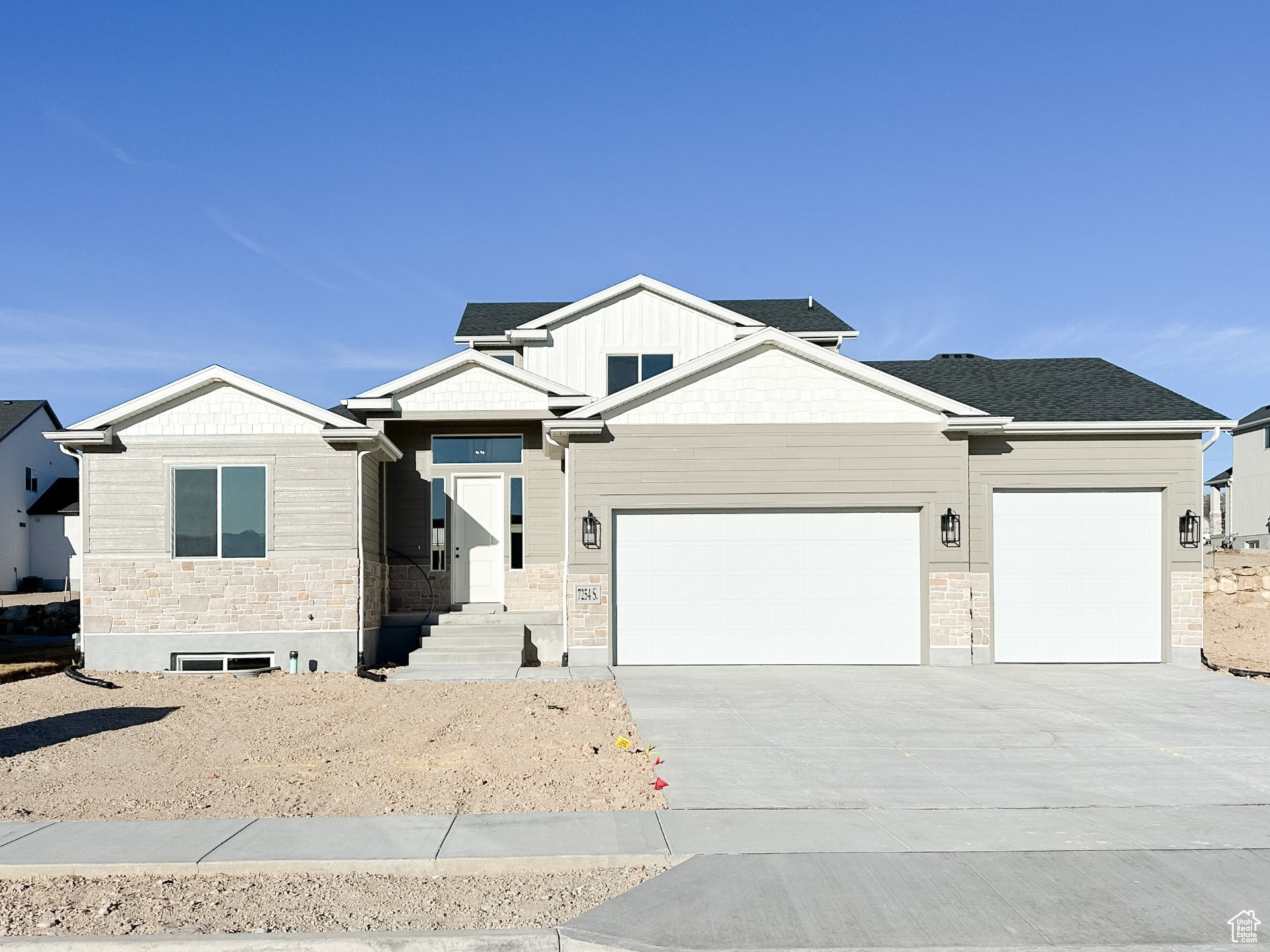 View of front of home with a garage, stone siding, concrete driveway, and a shingled roof