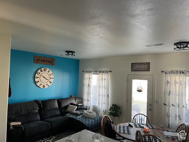Living room with visible vents and a textured ceiling