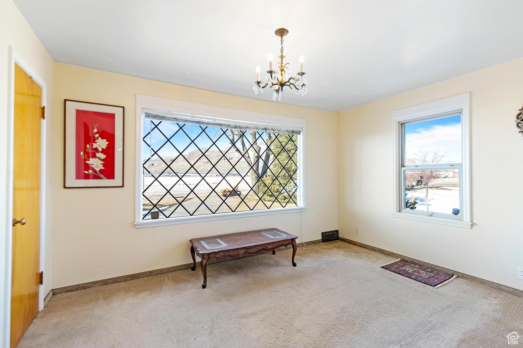 Carpeted dining room with baseboards and a notable chandelier