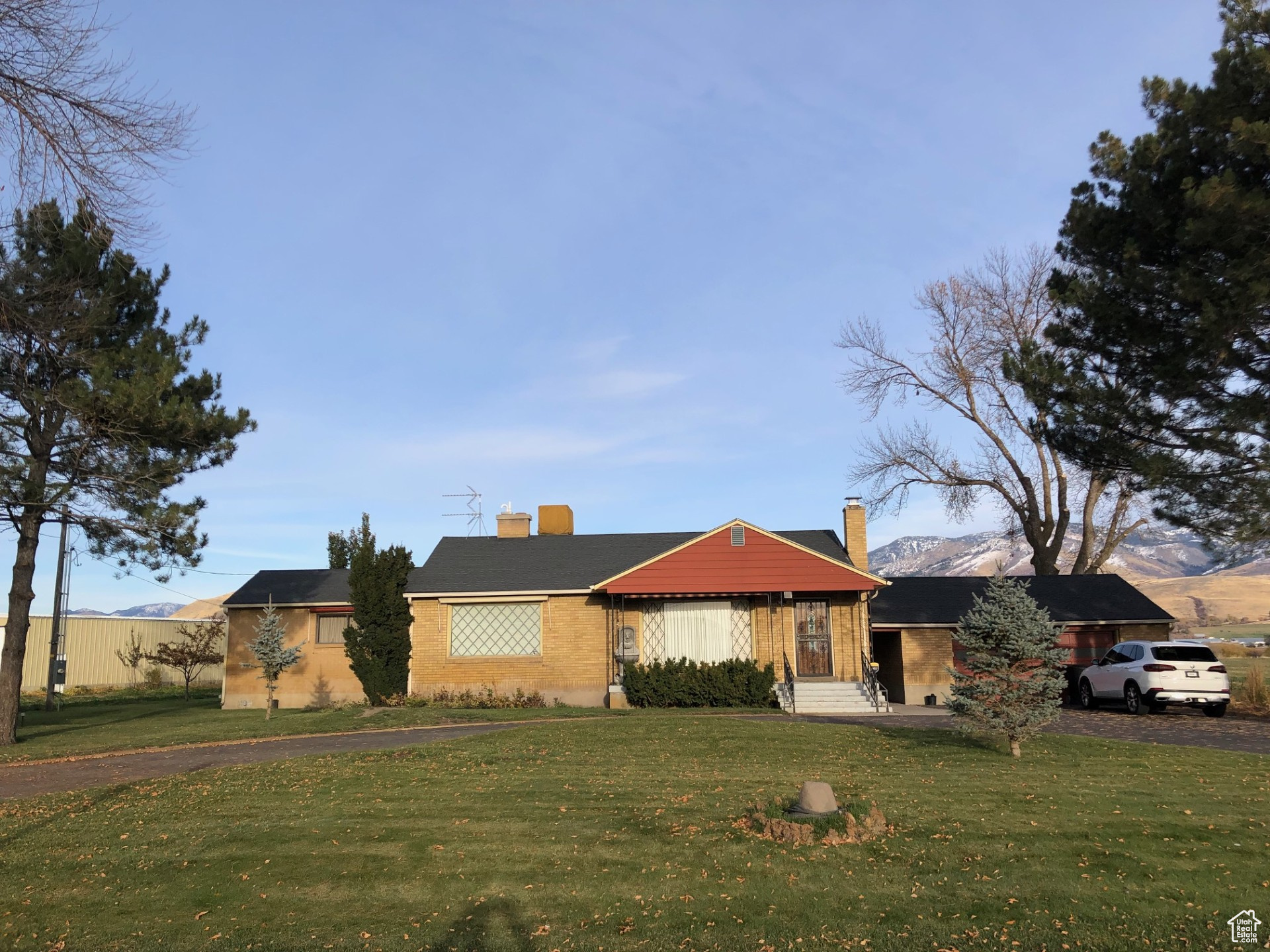 View of front of home featuring a front lawn, brick siding, and a chimney