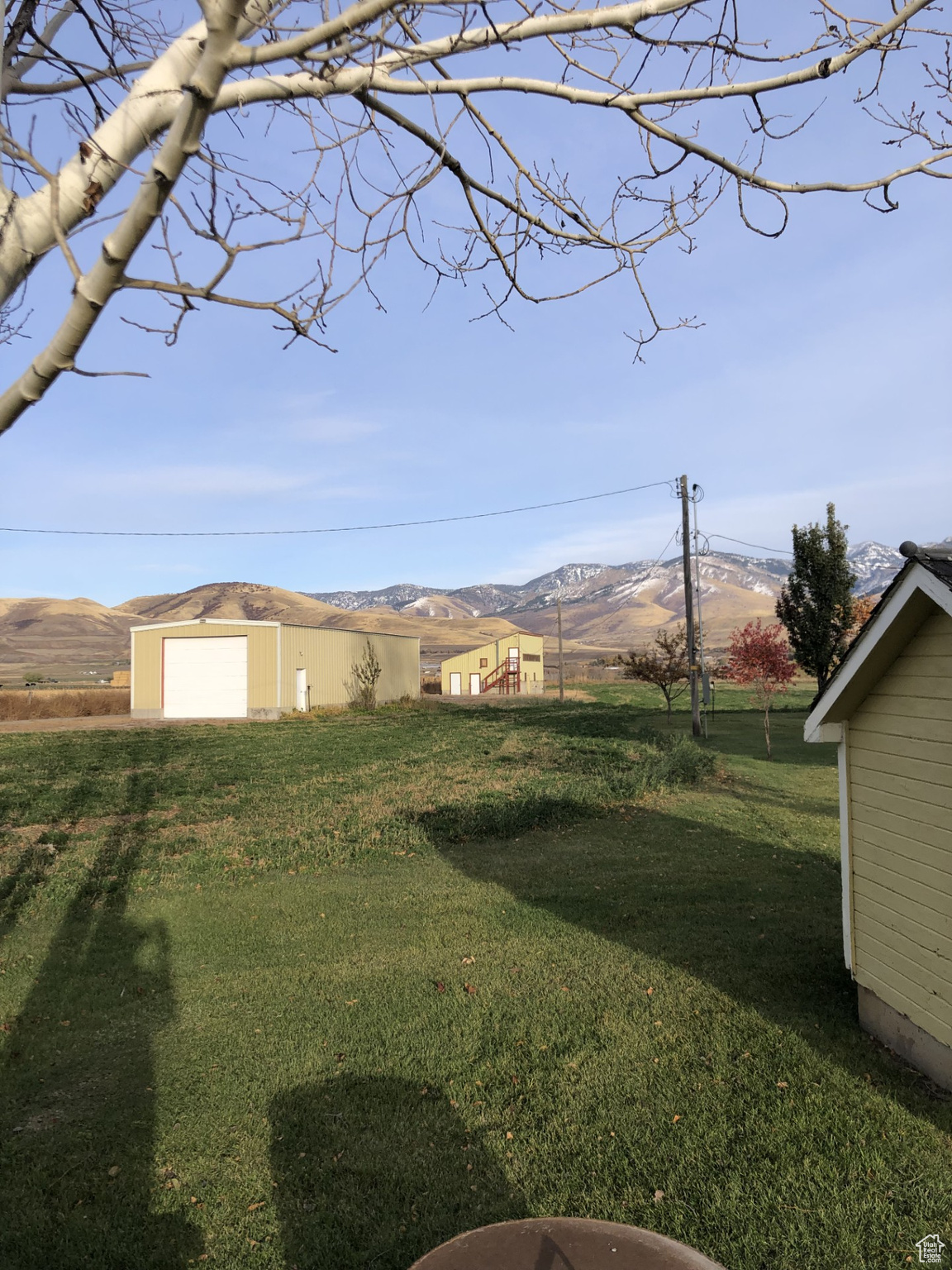 View of yard featuring a garage, a rural view, a mountain view, and an outdoor structure