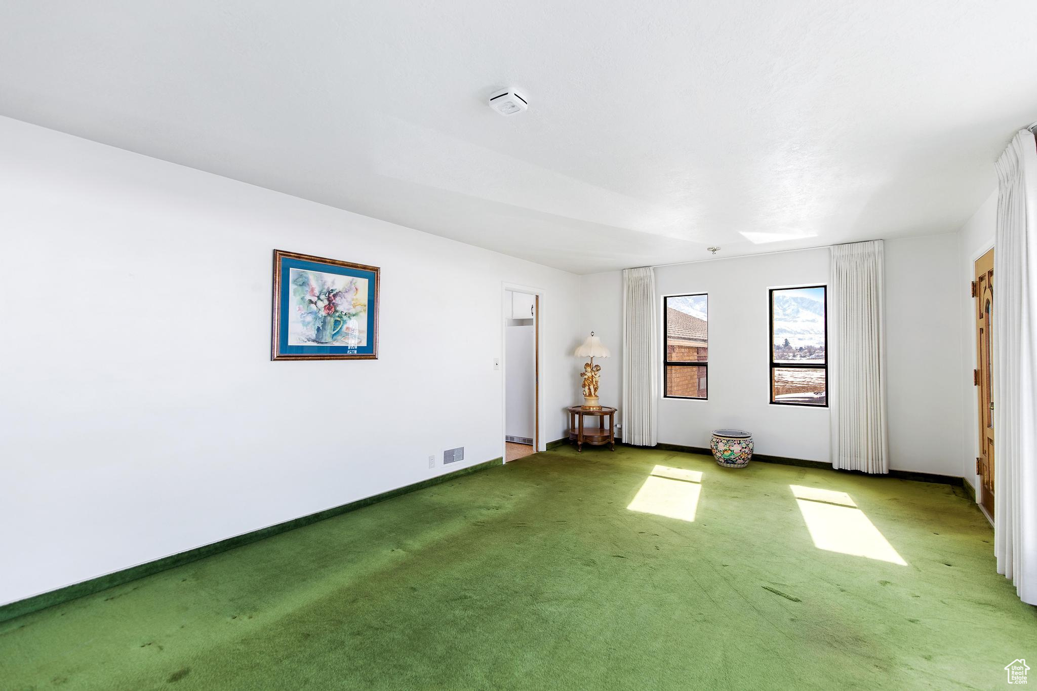 Carpeted spare room with baseboards