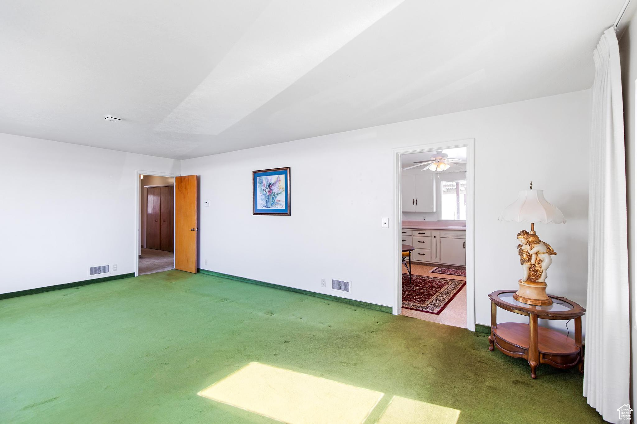 Unfurnished room featuring light colored carpet, visible vents, and baseboards