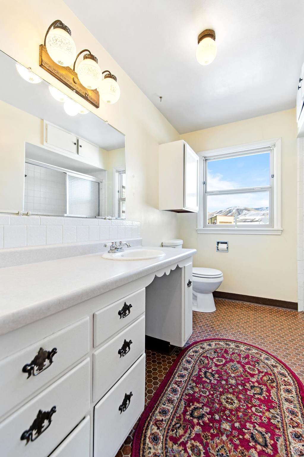 Bathroom with baseboards, toilet, and vanity