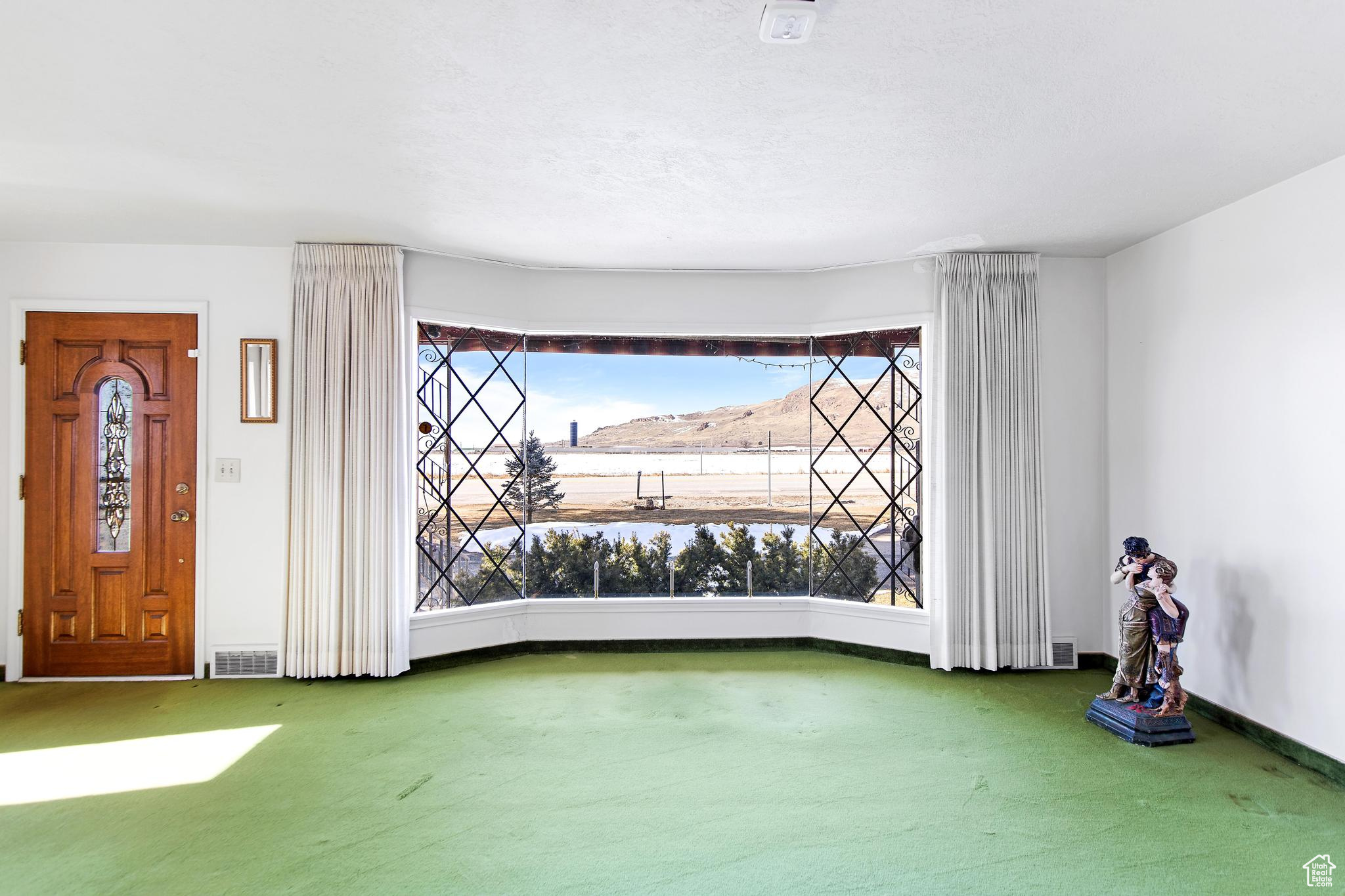 Interior space with visible vents, baseboards, and carpet