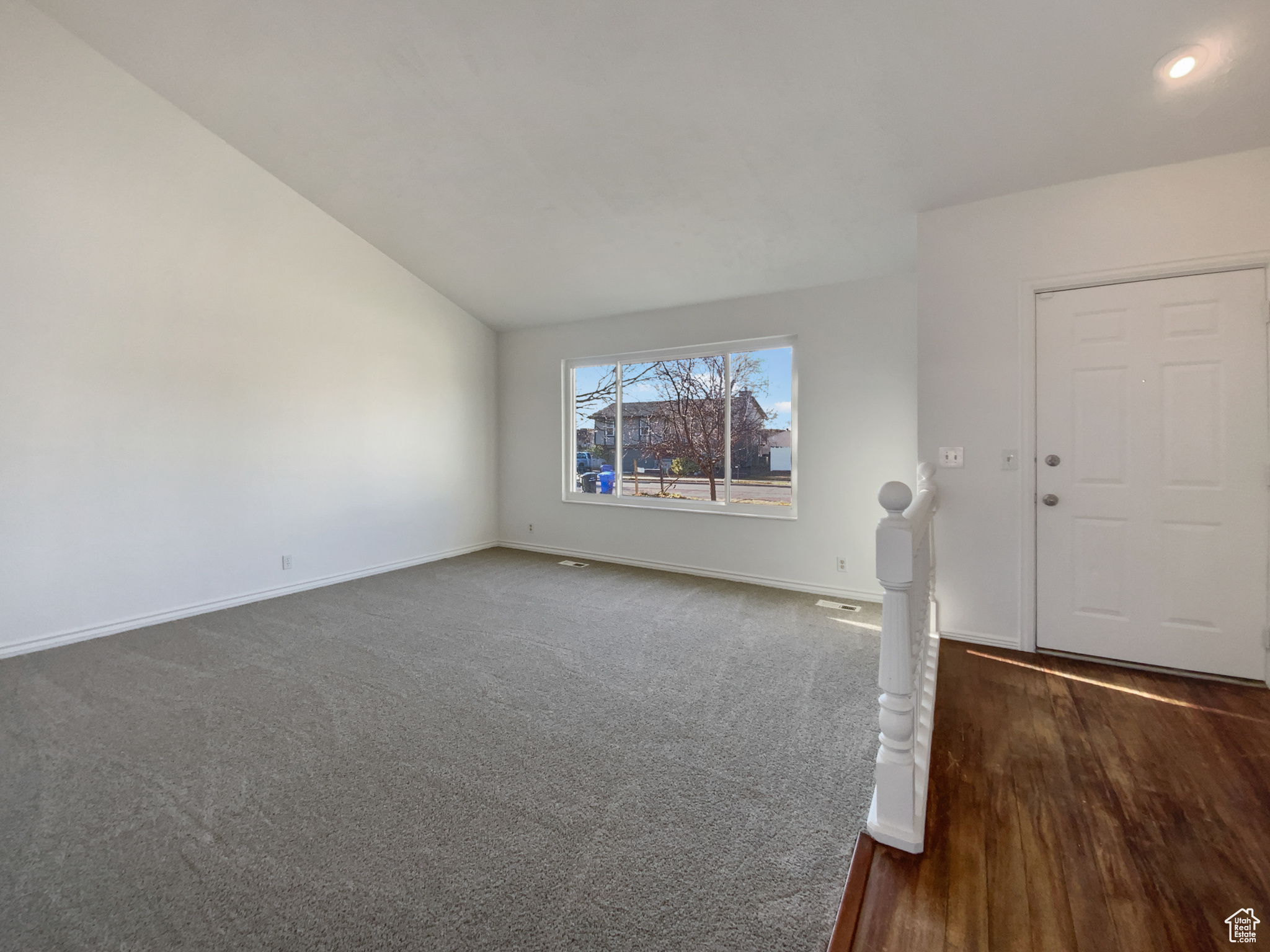 Interior space with baseboards, carpet, and vaulted ceiling