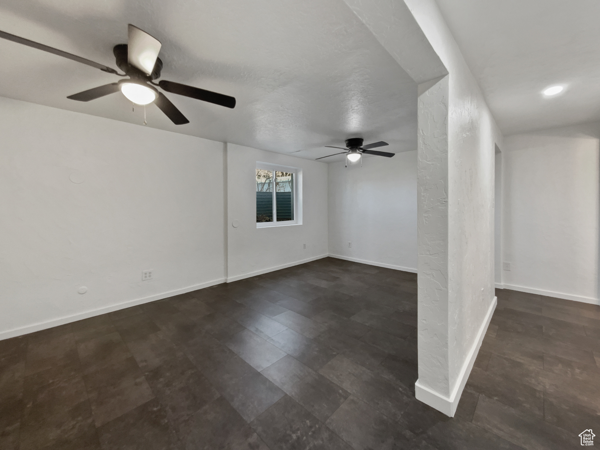 Empty room with baseboards and a ceiling fan
