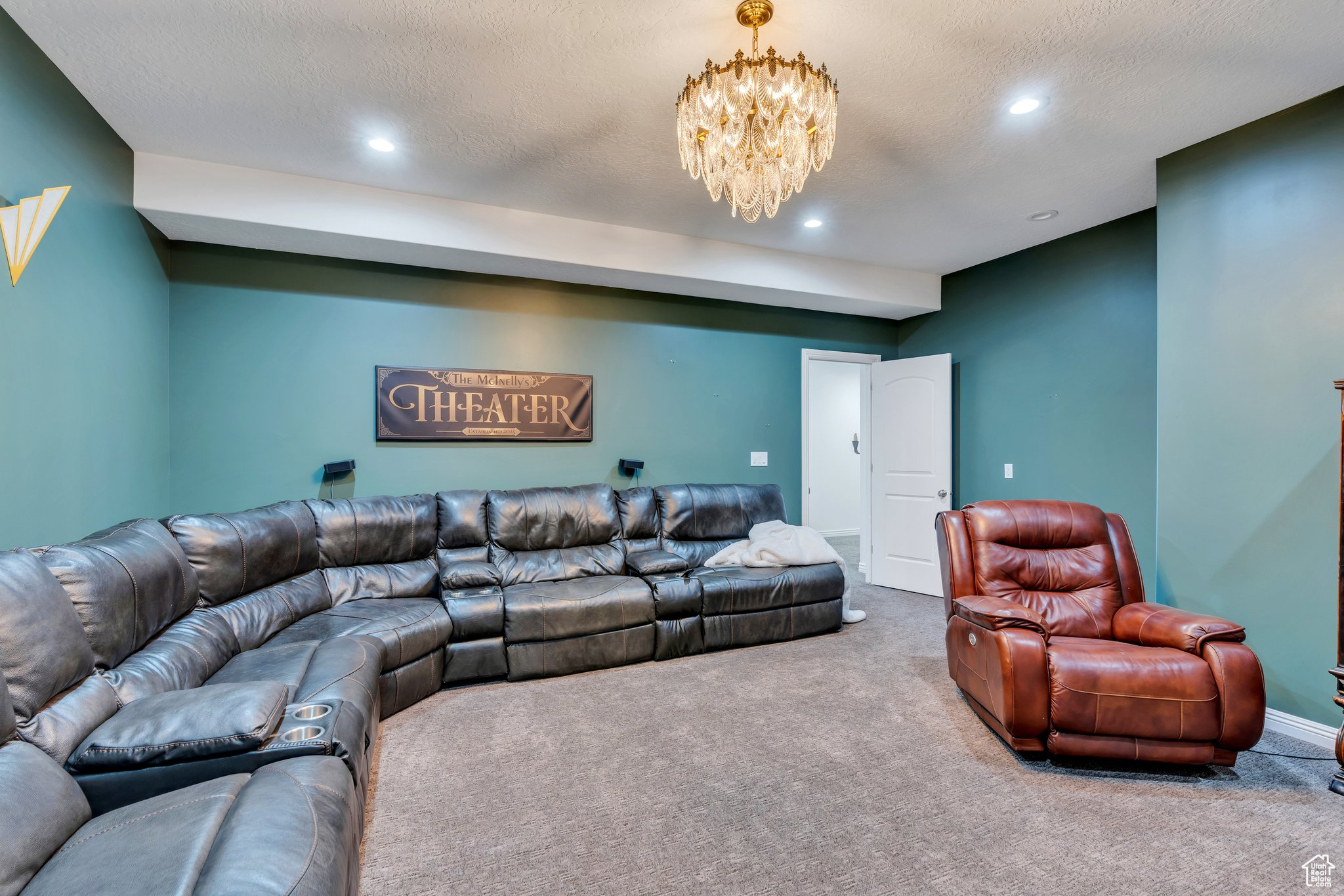 Carpeted living area with a notable chandelier, recessed lighting, baseboards, and a textured ceiling