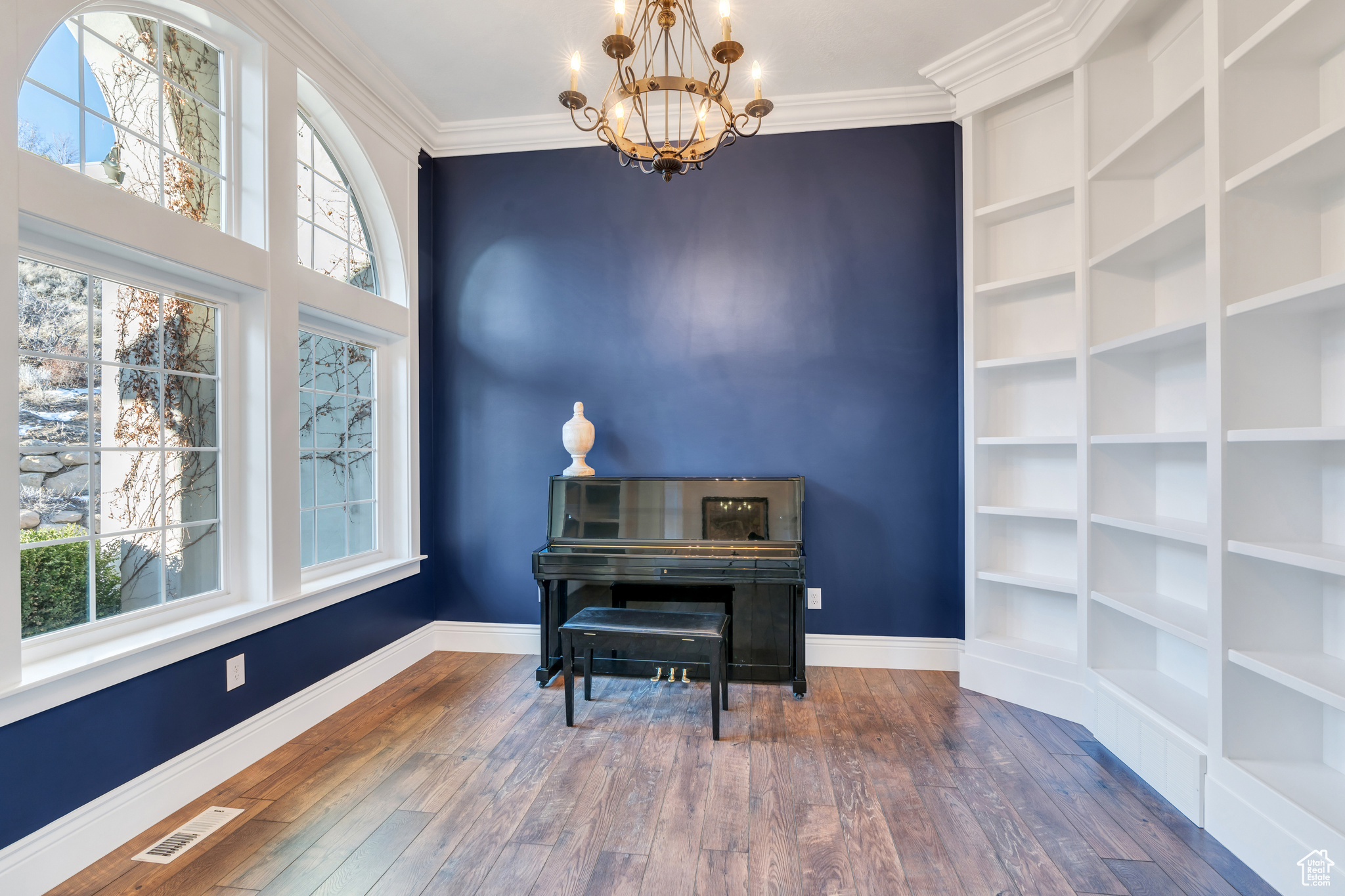 Sitting room featuring visible vents, plenty of natural light, wood-type flooring, and ornamental molding