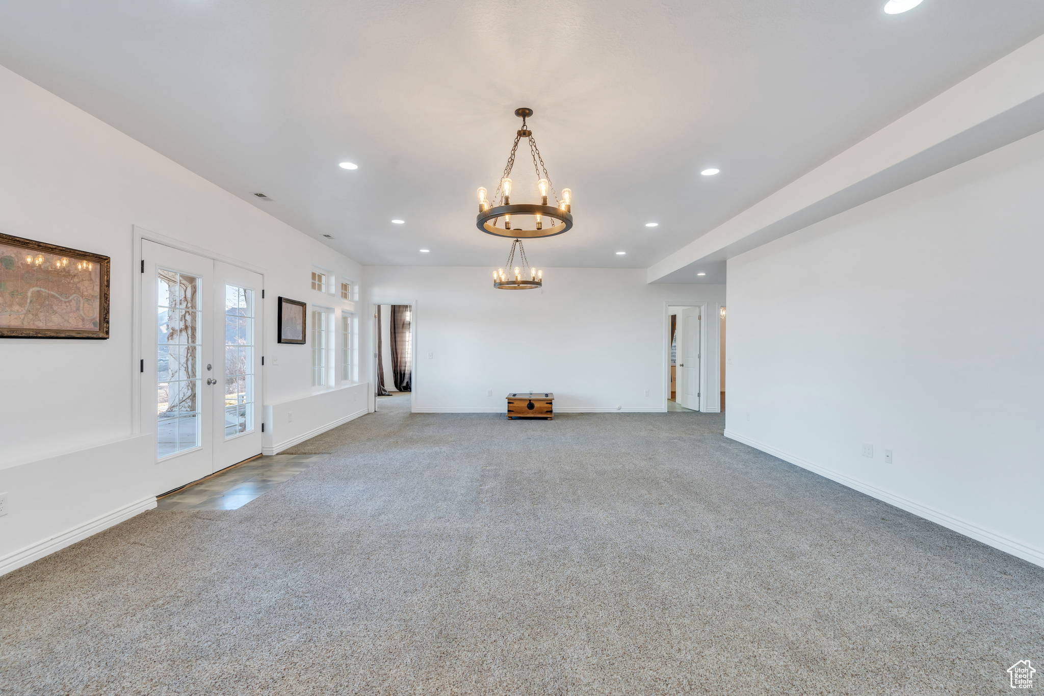 Unfurnished living room featuring recessed lighting, french doors, baseboards, and carpet