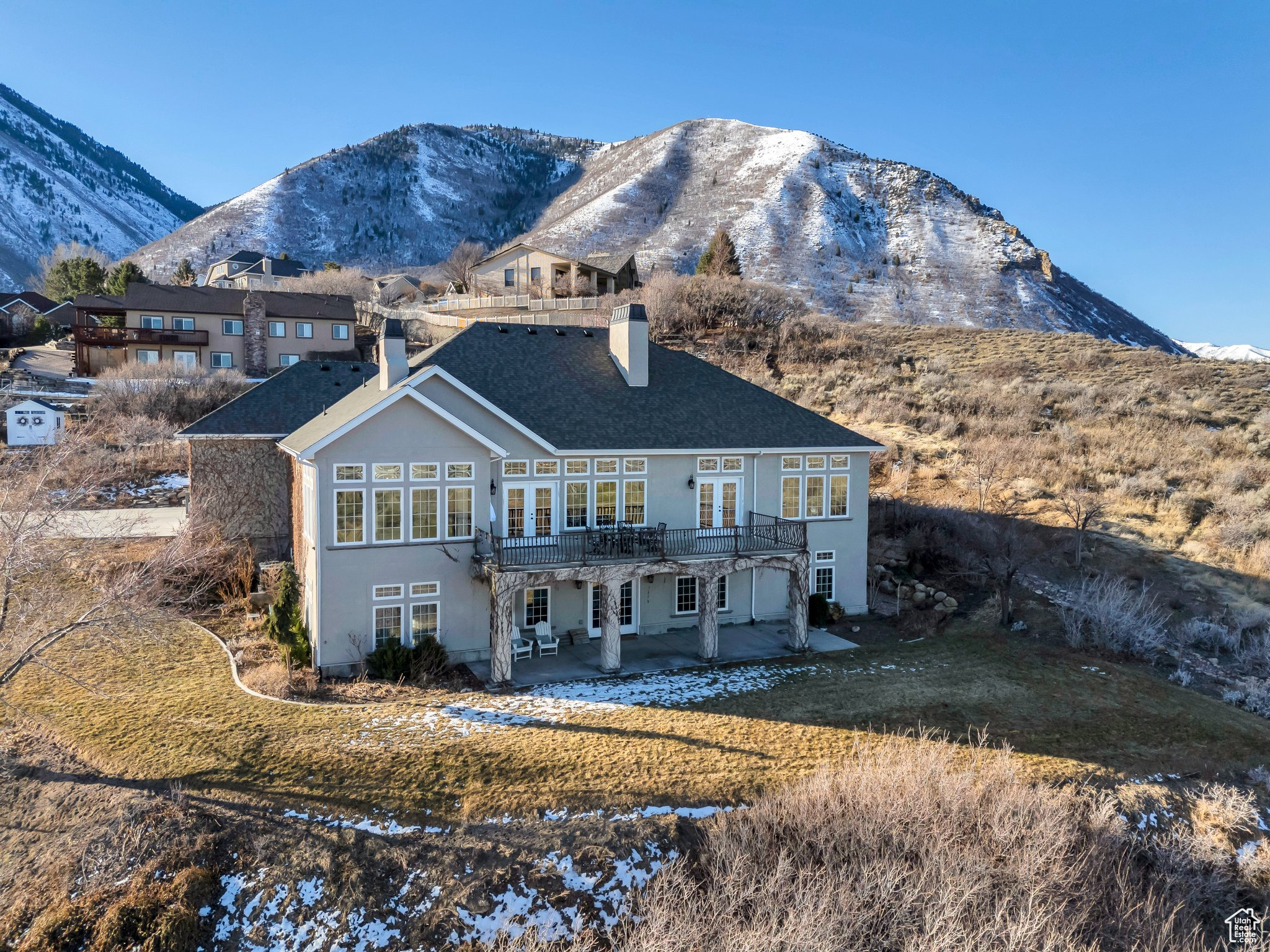 Back of property with a patio area, stucco siding, a mountain view, and a chimney