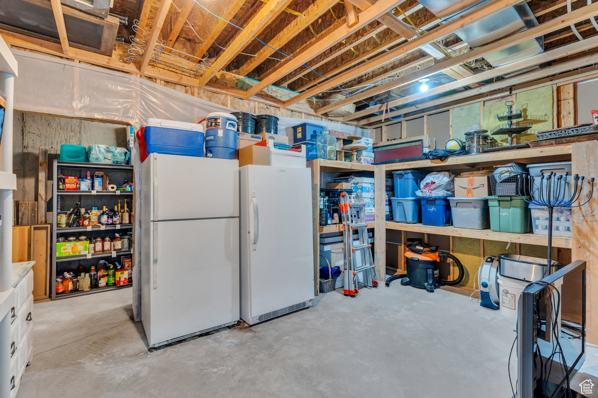 Unfinished below grade area with freestanding refrigerator