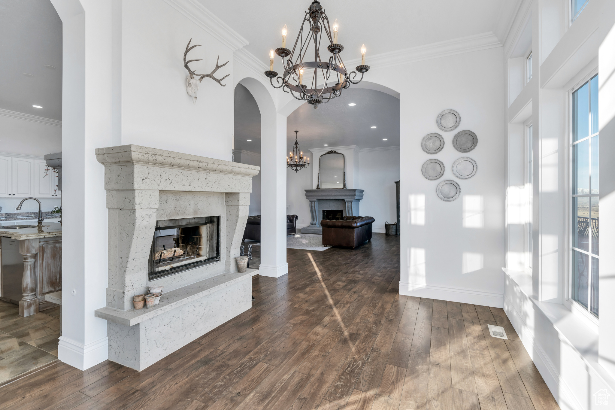 Interior space with dark wood finished floors, a fireplace with raised hearth, visible vents, and ornamental molding