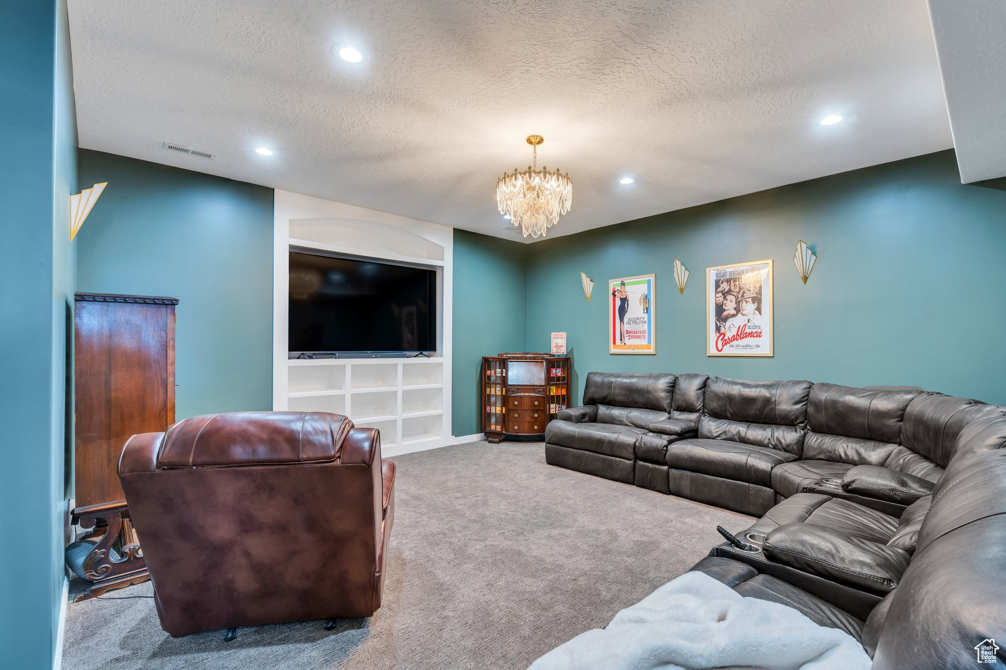 Carpeted living room with a chandelier, visible vents, recessed lighting, and a textured ceiling