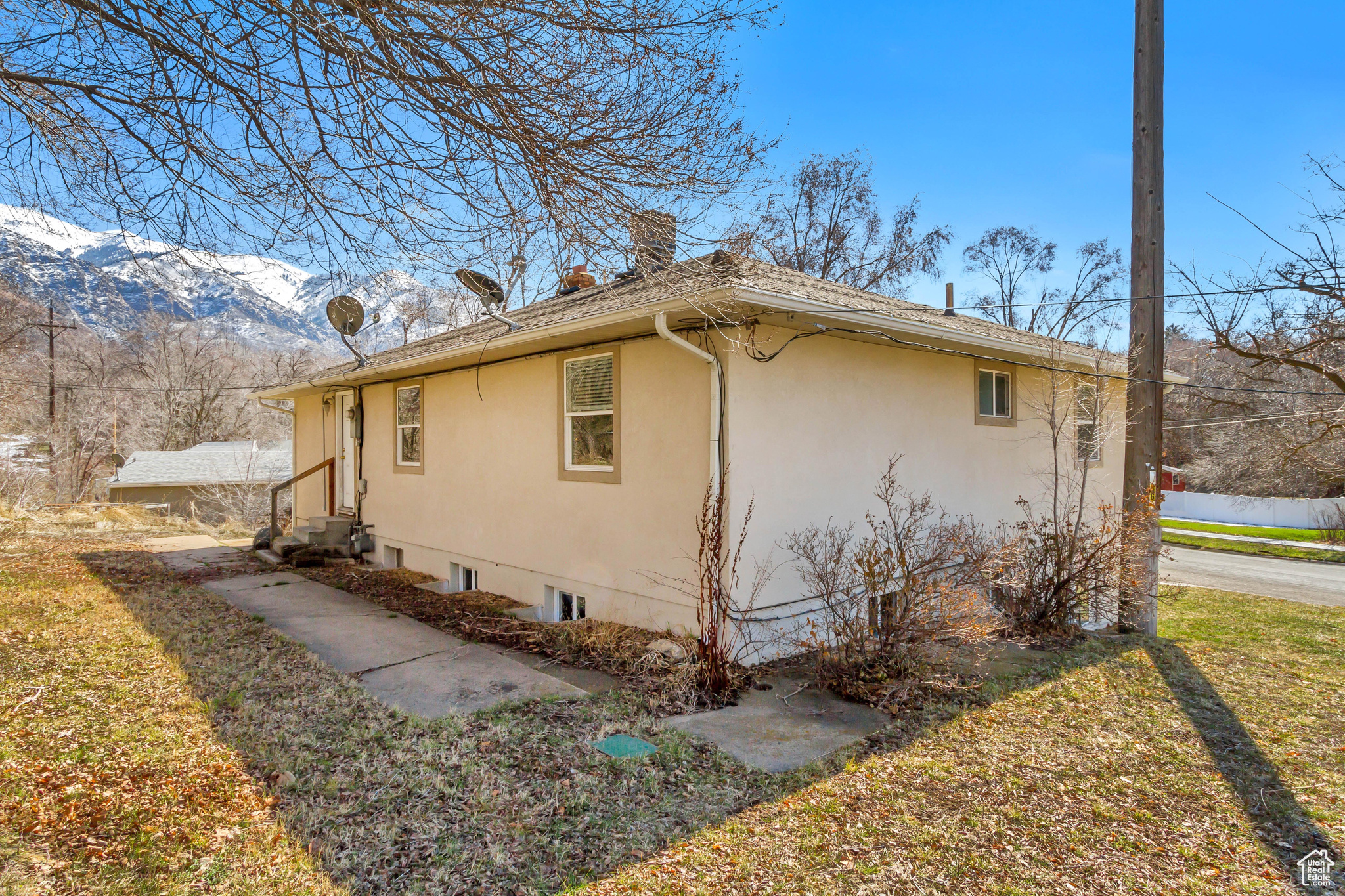 View of home's exterior featuring a mountain view, stucco siding, entry steps, and a chimney