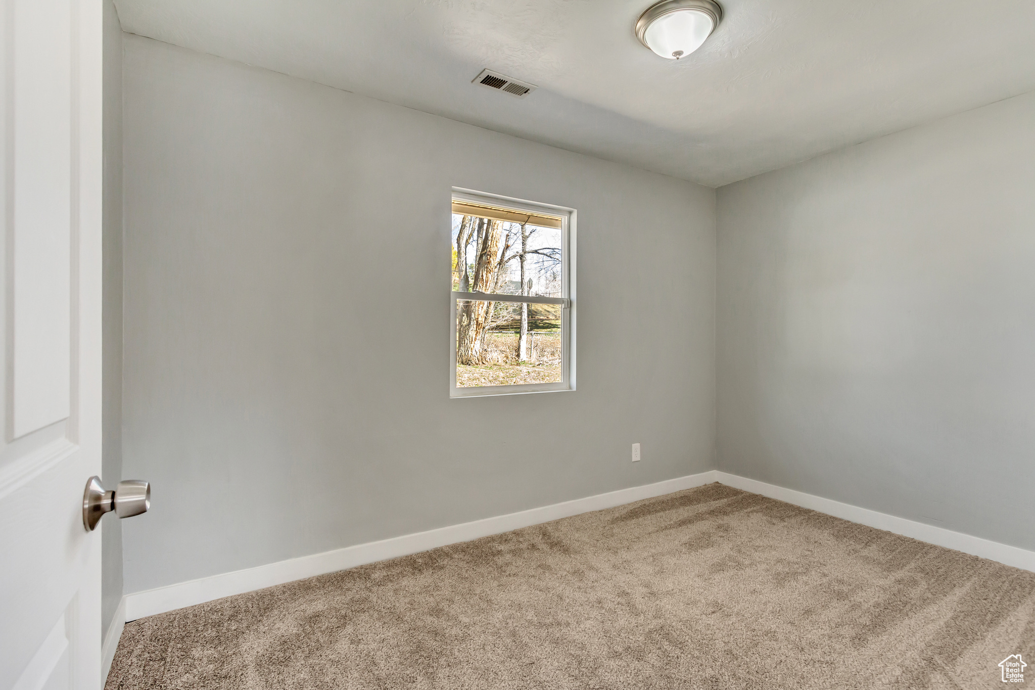 Spare room with carpet flooring, baseboards, and visible vents