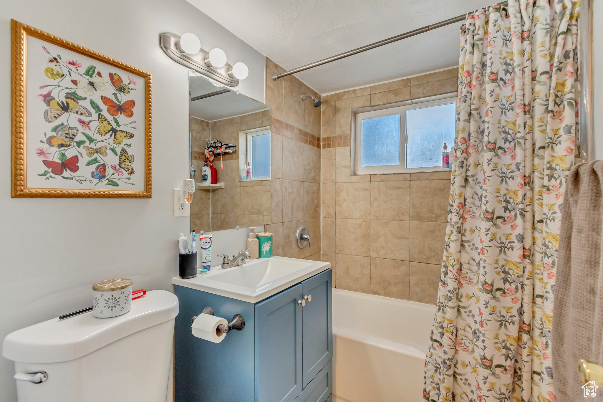 Bathroom with vanity, toilet, and shower / bath combo with shower curtain