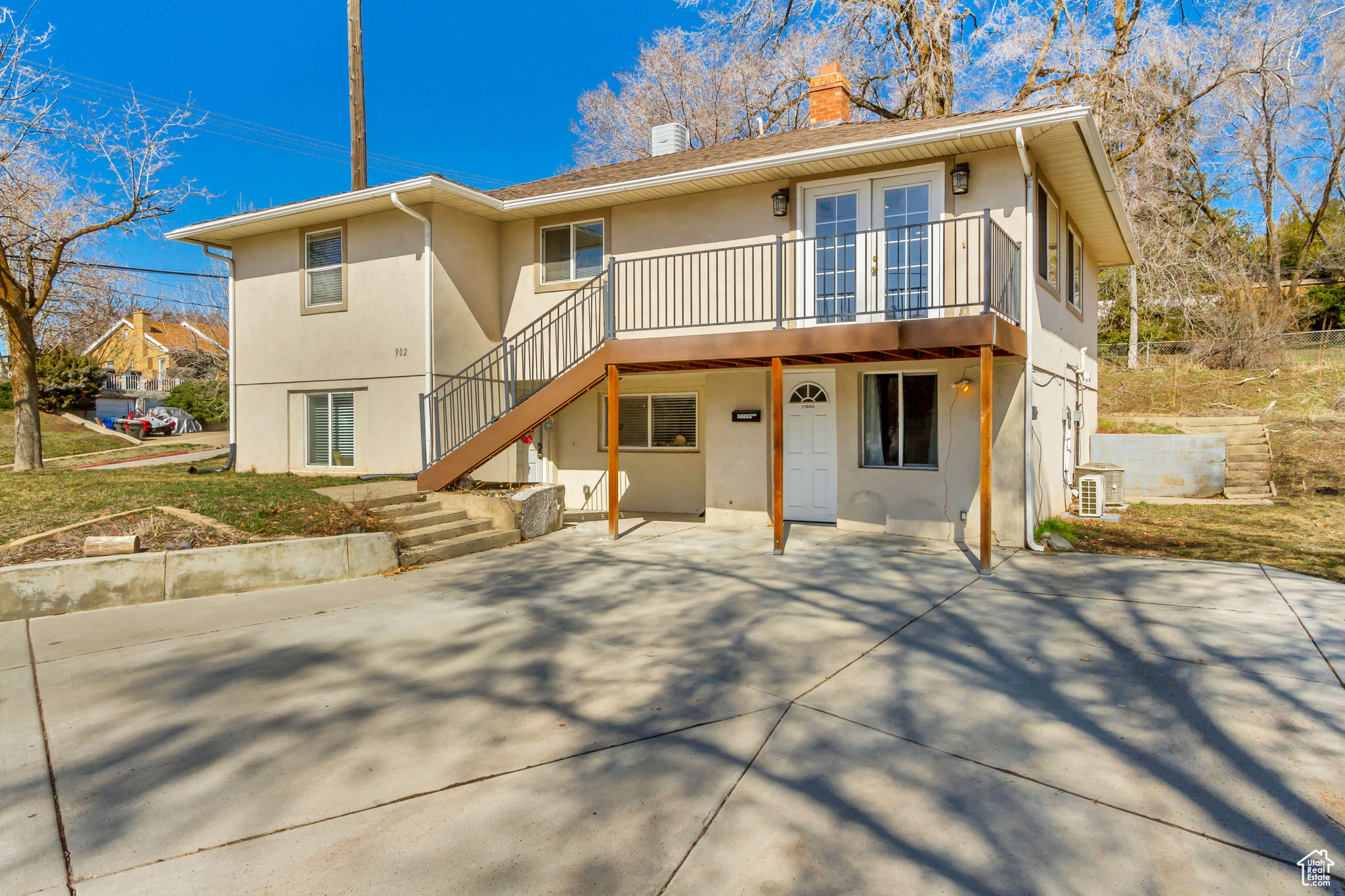 Back of property with stairs, french doors, a chimney, and stucco siding