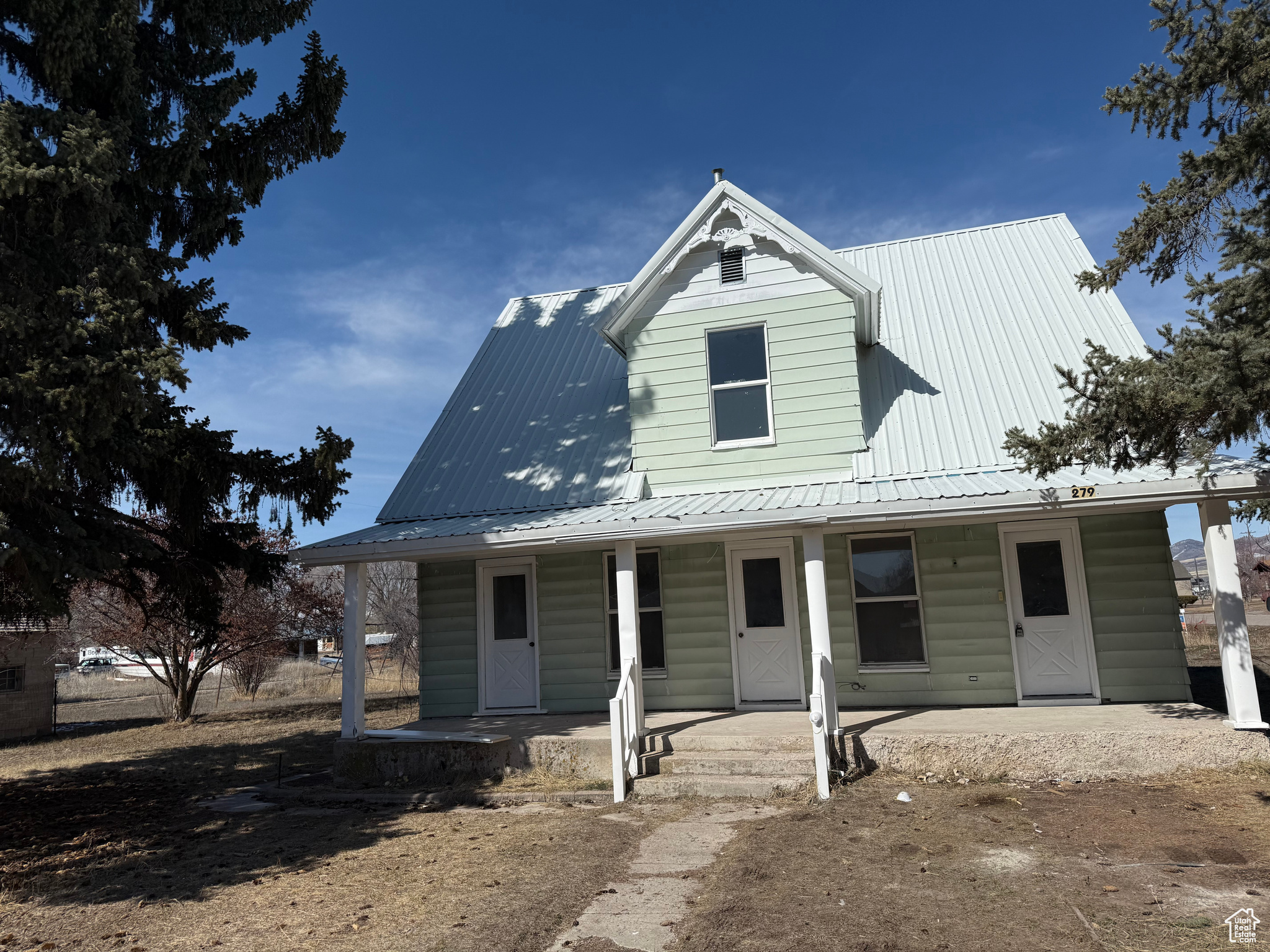 View of front of property featuring covered porch and metal roof