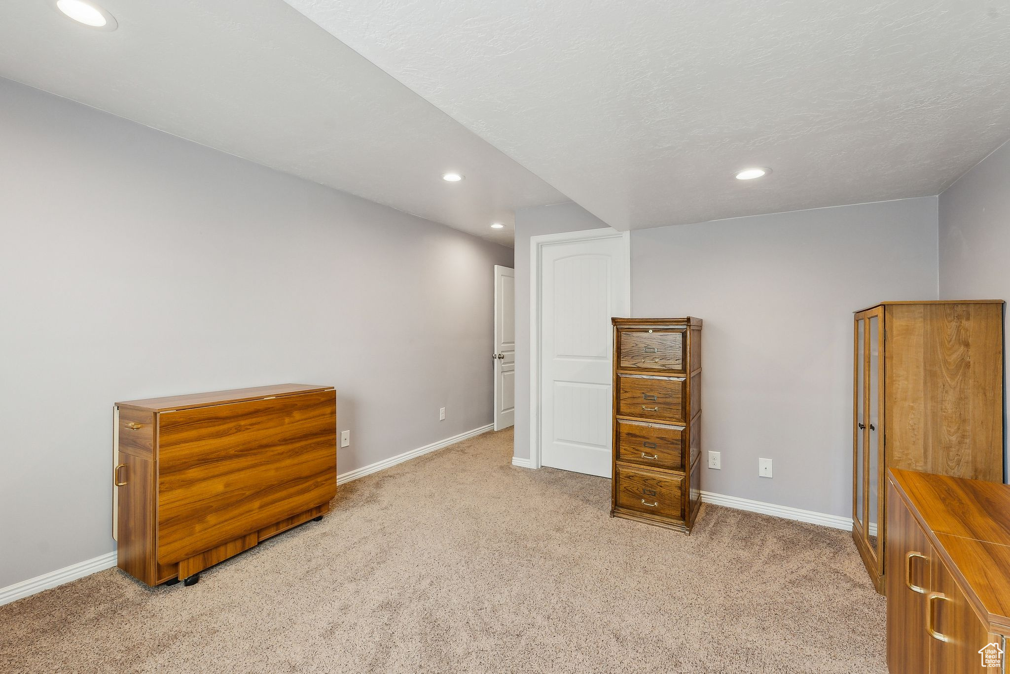 Interior space with recessed lighting, baseboards, and light carpet