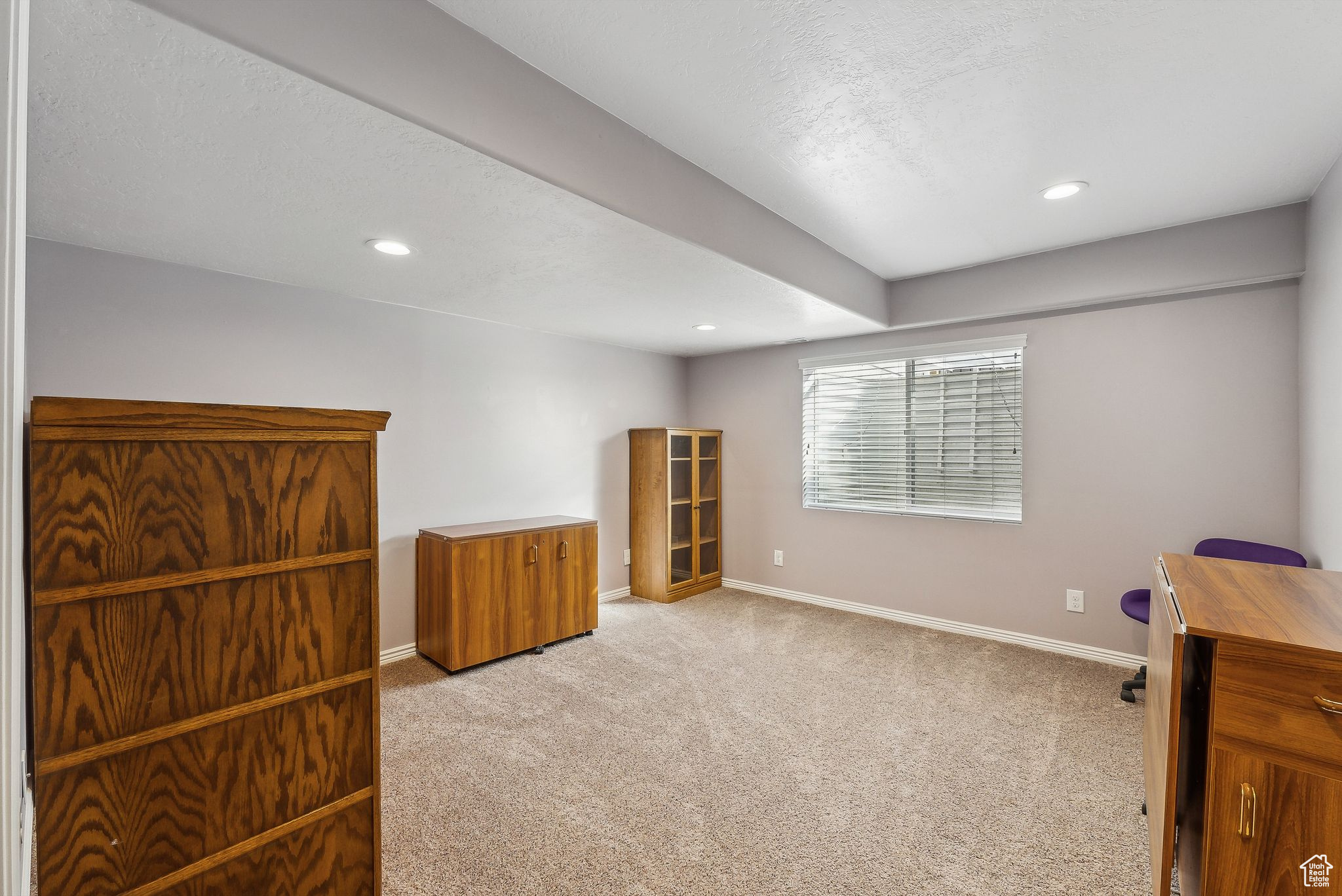 Interior space featuring a textured ceiling, recessed lighting, baseboards, and light carpet