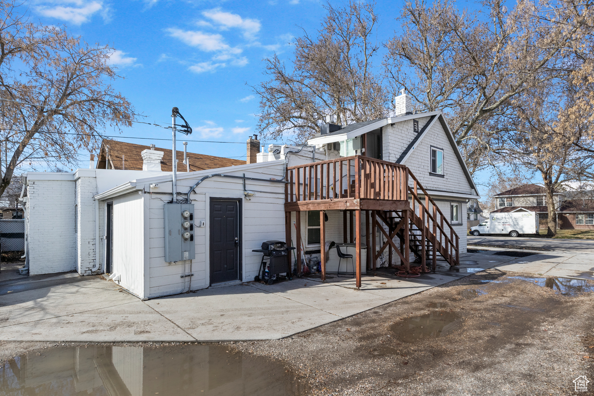 Rear view of property with a deck, stairway, and a chimney