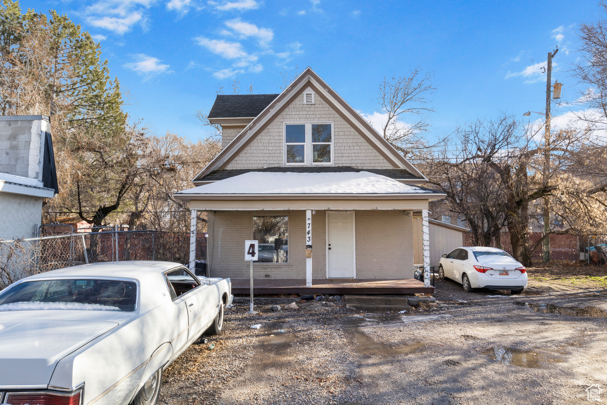View of front of house featuring covered porch and fence