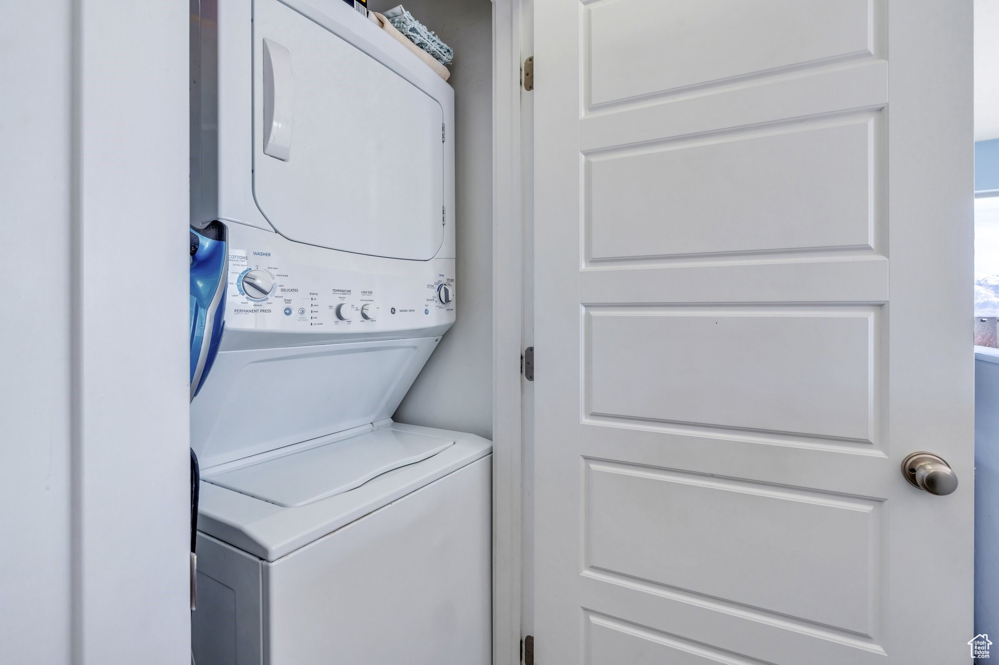 Washroom with laundry area and stacked washer and clothes dryer