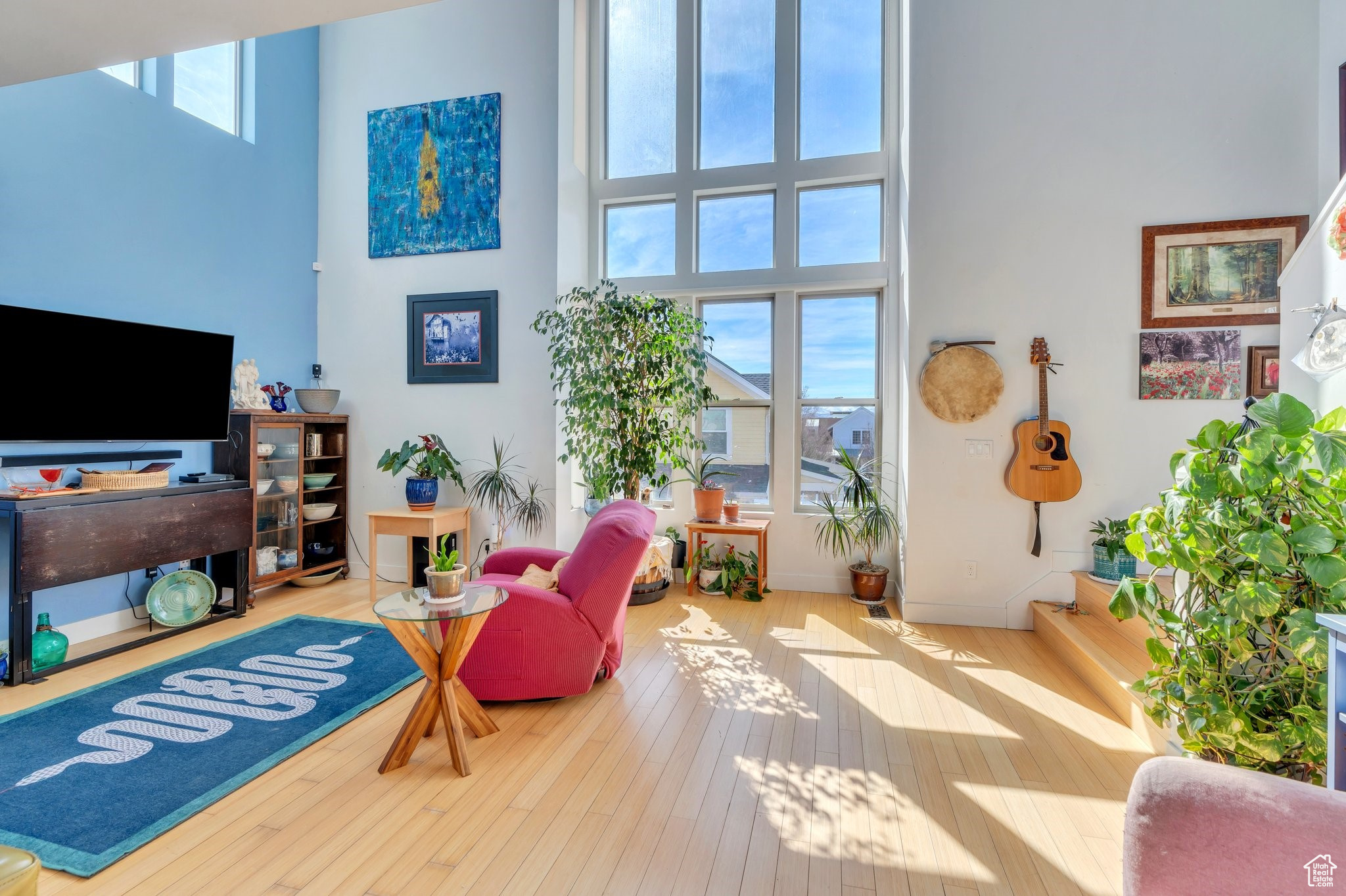 Interior space featuring a healthy amount of sunlight, a high ceiling, baseboards, and wood-type flooring