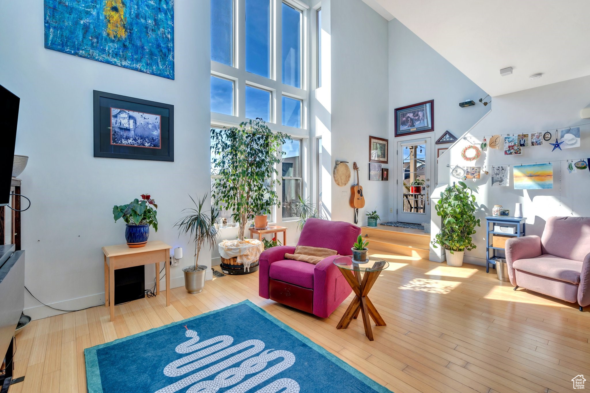 Living area featuring a high ceiling, baseboards, and hardwood / wood-style flooring