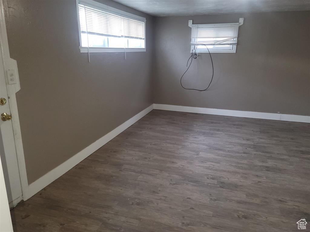 Basement featuring dark wood finished floors and baseboards