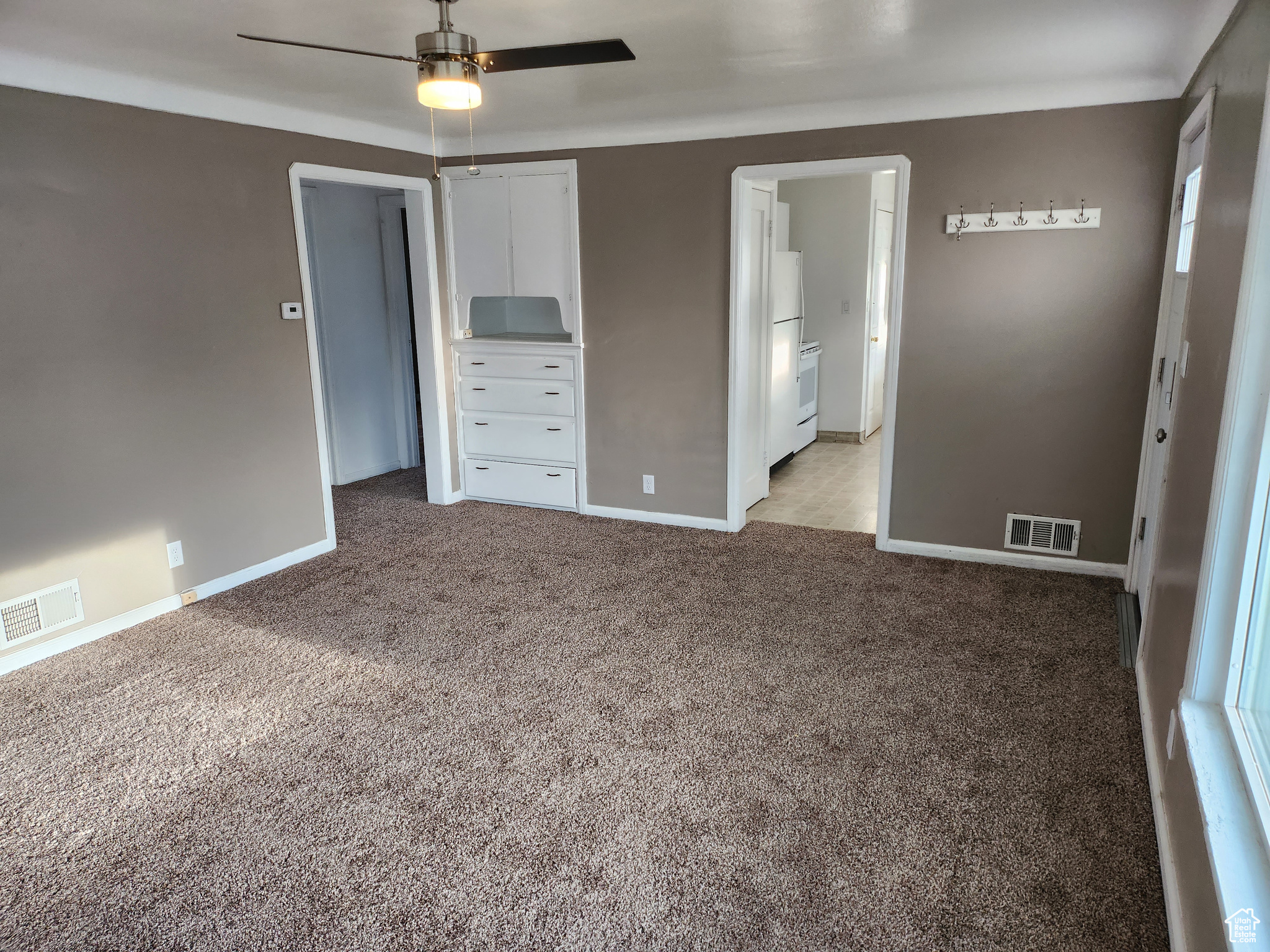 Unfurnished bedroom featuring visible vents, baseboards, and light colored carpet