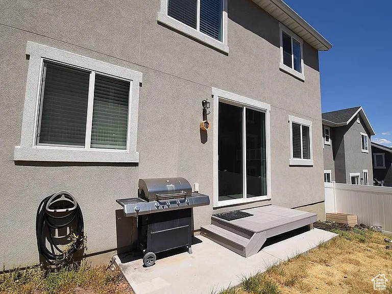 Back of house with stucco siding and fence