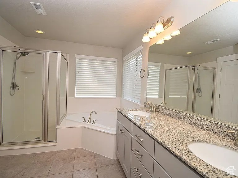 Full bath with tile patterned floors, a stall shower, and a sink