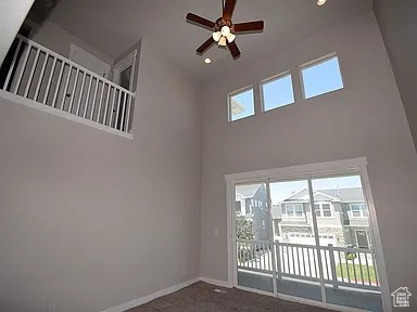 Empty room featuring a wealth of natural light, baseboards, and a high ceiling